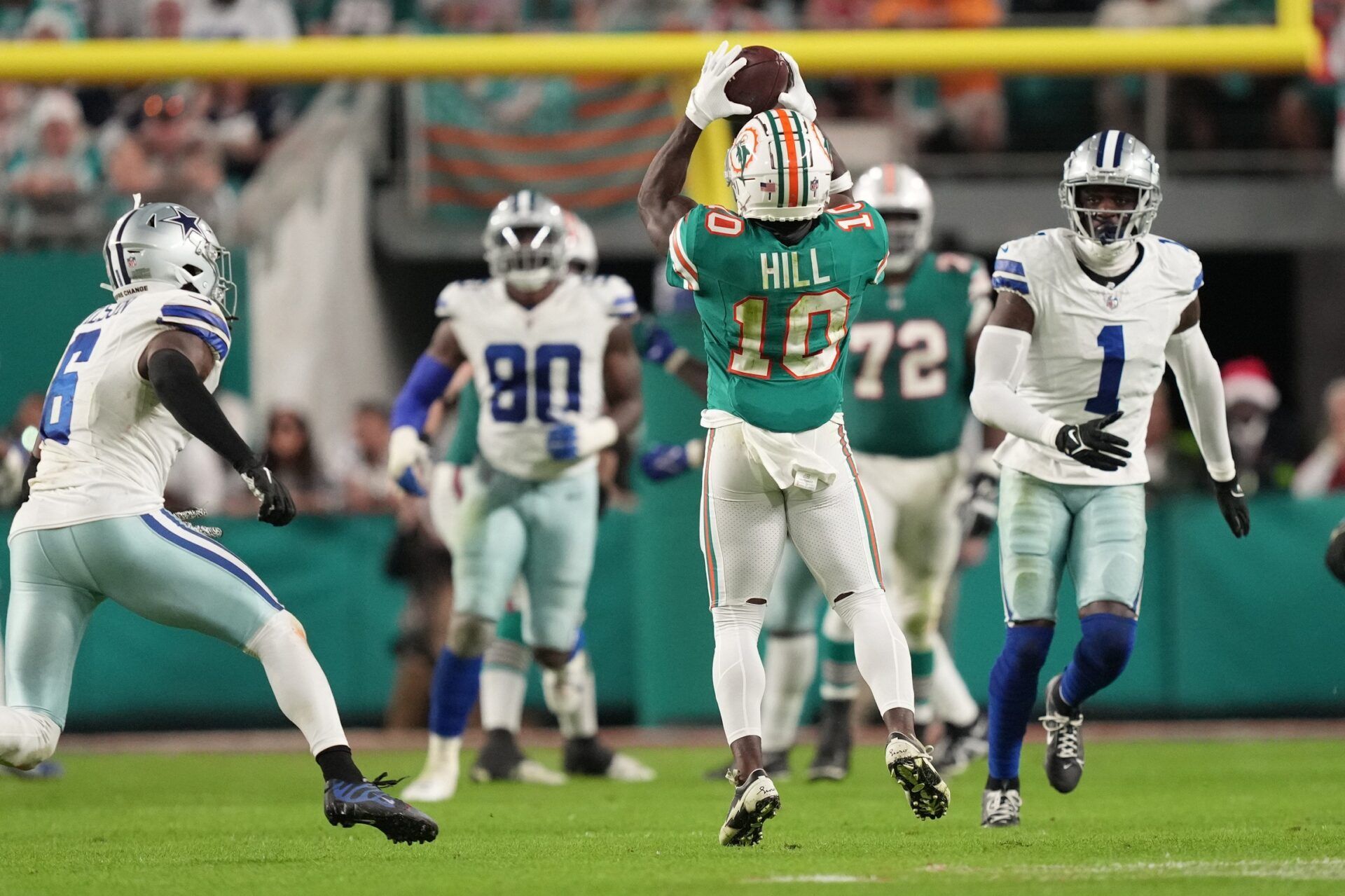 Miami Dolphins wide receiver Tyreek Hill (10) catches a pass in the middle of Dallas Cowboys defenders during the second half of an NFL game at Hard Rock Stadium.