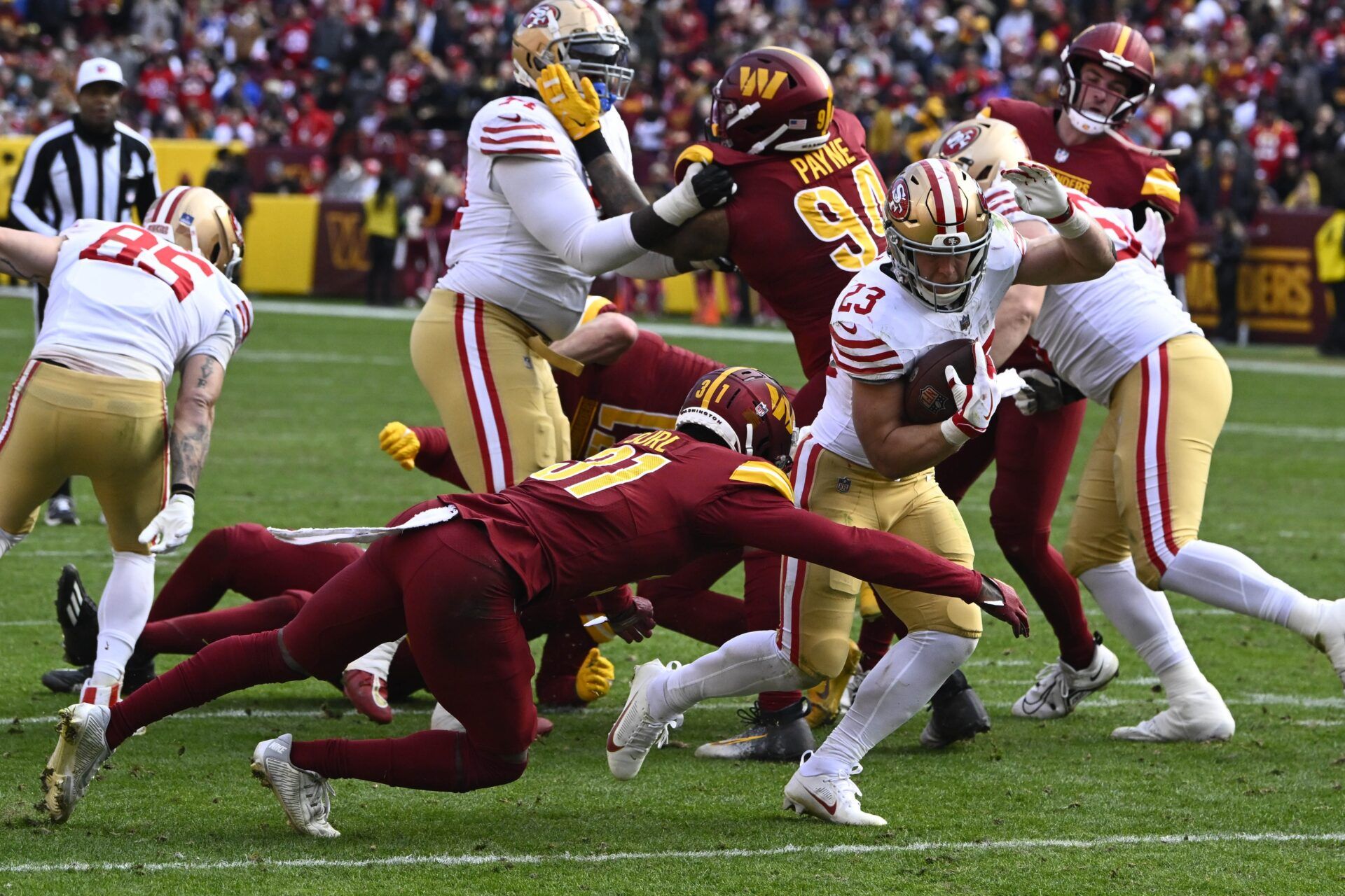 San Francisco 49ers running back Christian McCaffrey (23) is tackled by Washington Commanders safety Kamren Curl (31).