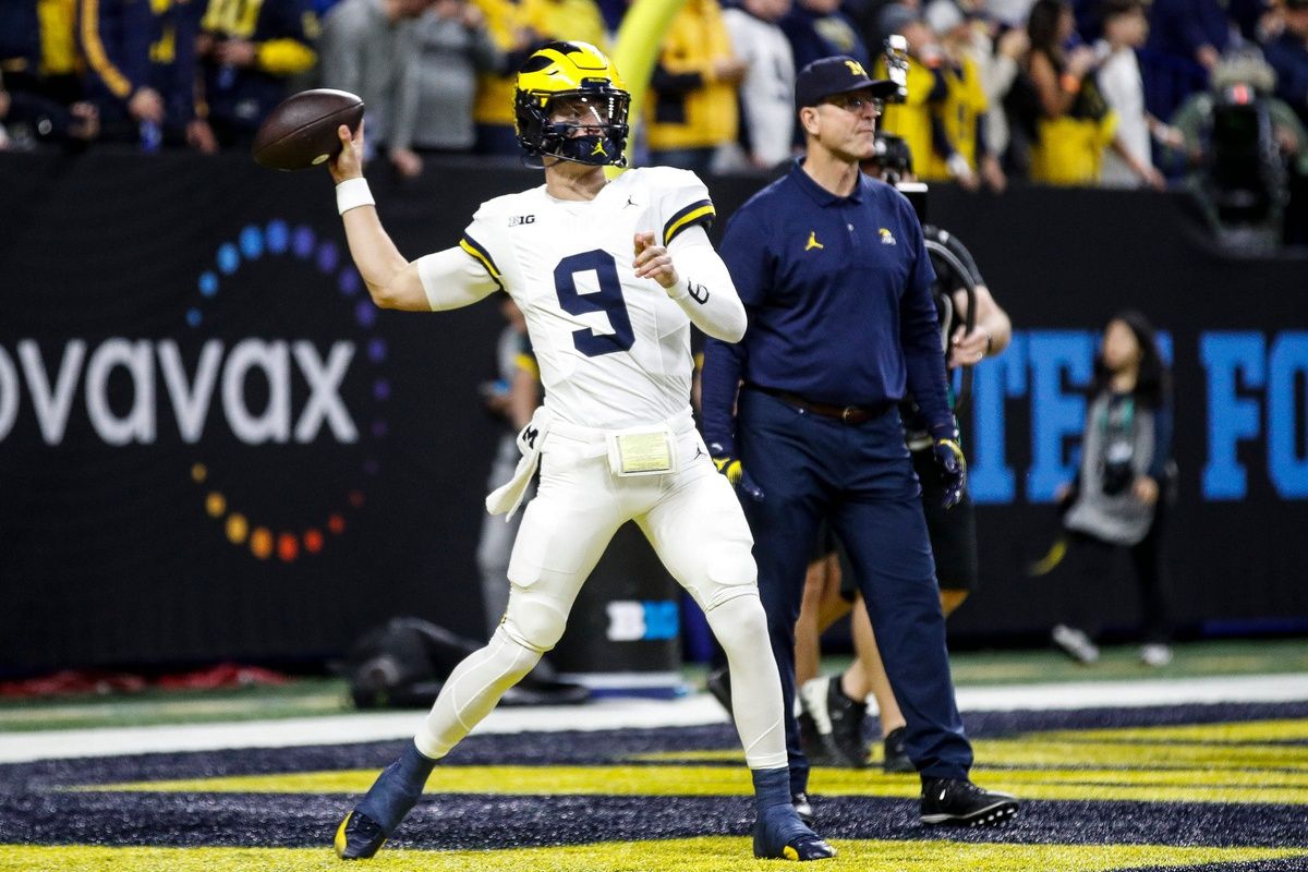 Michigan head coach Jim Harbaugh watches quarterback J.J. McCarthy warm up before the Big Ten championship game.