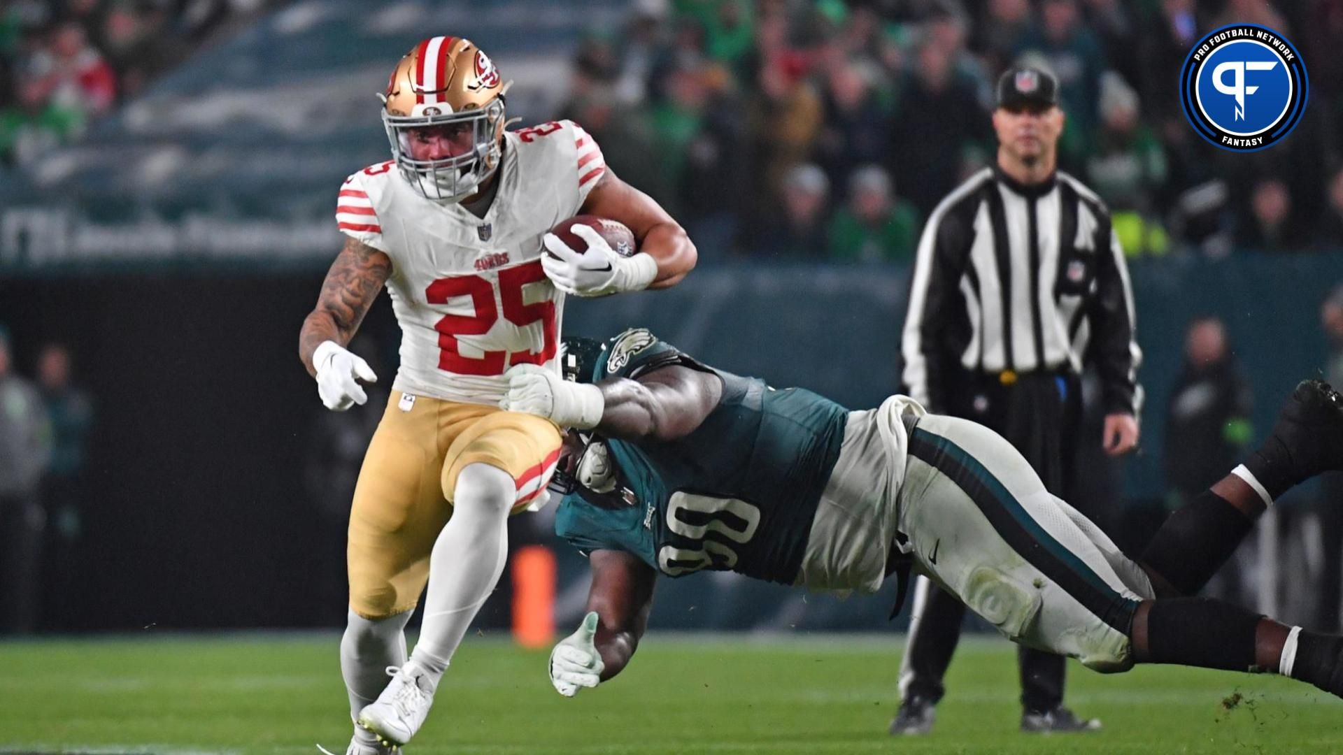 San Francisco 49ers running back Elijah Mitchell (25) runs past Philadelphia Eagles defensive tackle Jordan Davis (90) at Lincoln Financial Field.