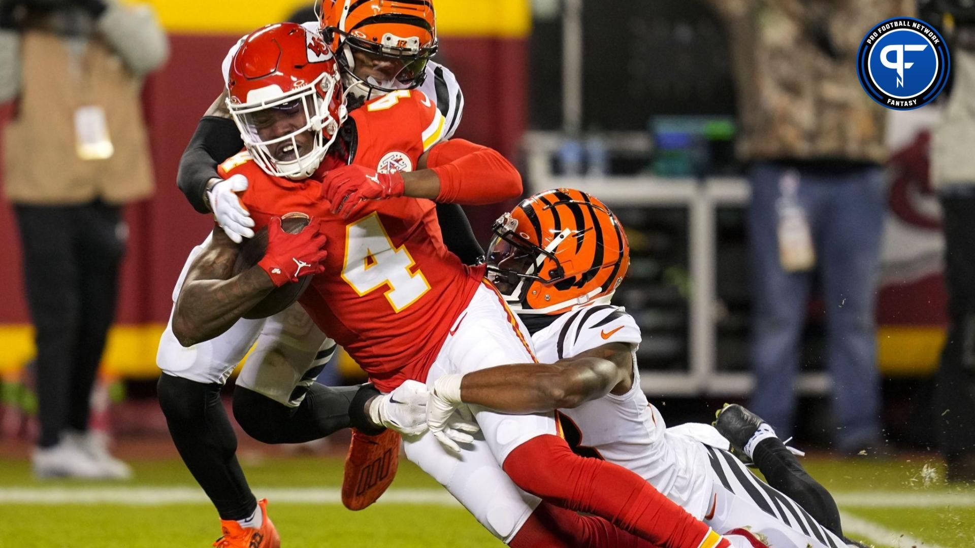 Kansas City Chiefs wide receiver Rashee Rice (4) is tackled by Cincinnati Bengals safety Dax Hill (23) and cornerback Cam Taylor-Britt (29) during the second half at GEHA Field at Arrowhead Stadium.