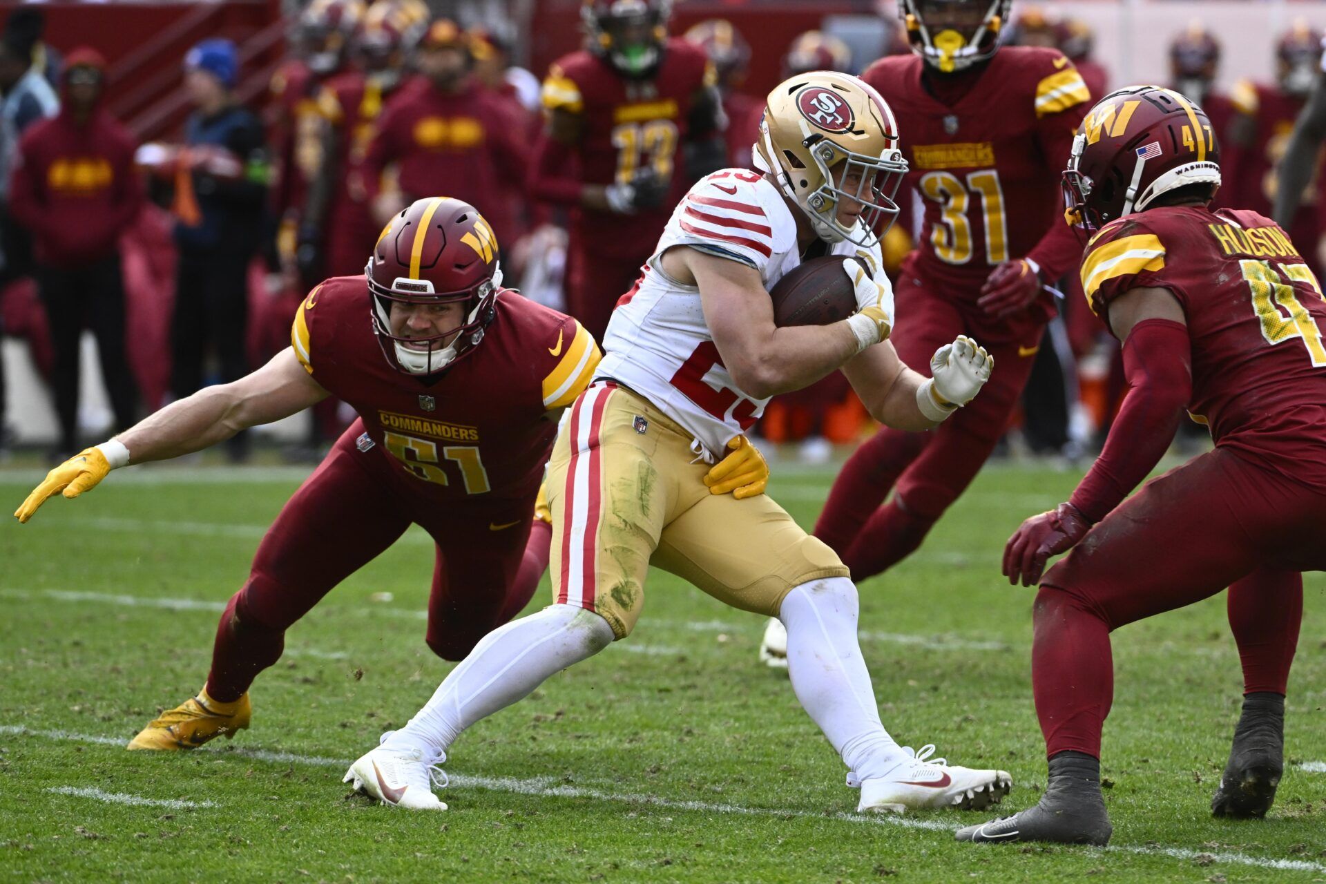 San Francisco 49ers RB Christian McCaffrey (23) tries to evade a swarm of Washington Commanders defensive players.