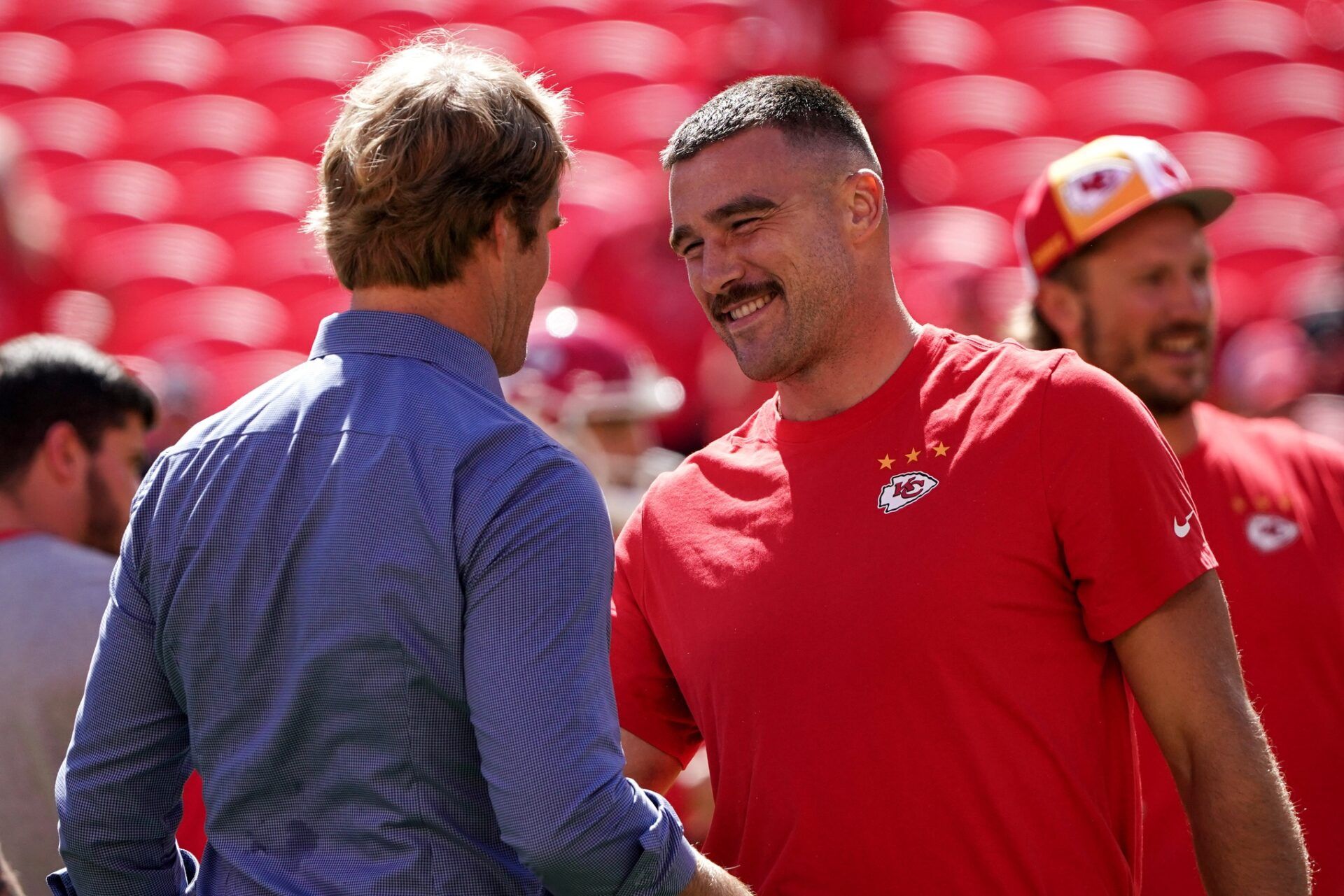 Sports broadcaster Greg Olsen talks with Kansas City Chiefs tight end Travis Kelce (87) against the Chicago Bears prior to a game at GEHA Field at Arrowhead Stadium.