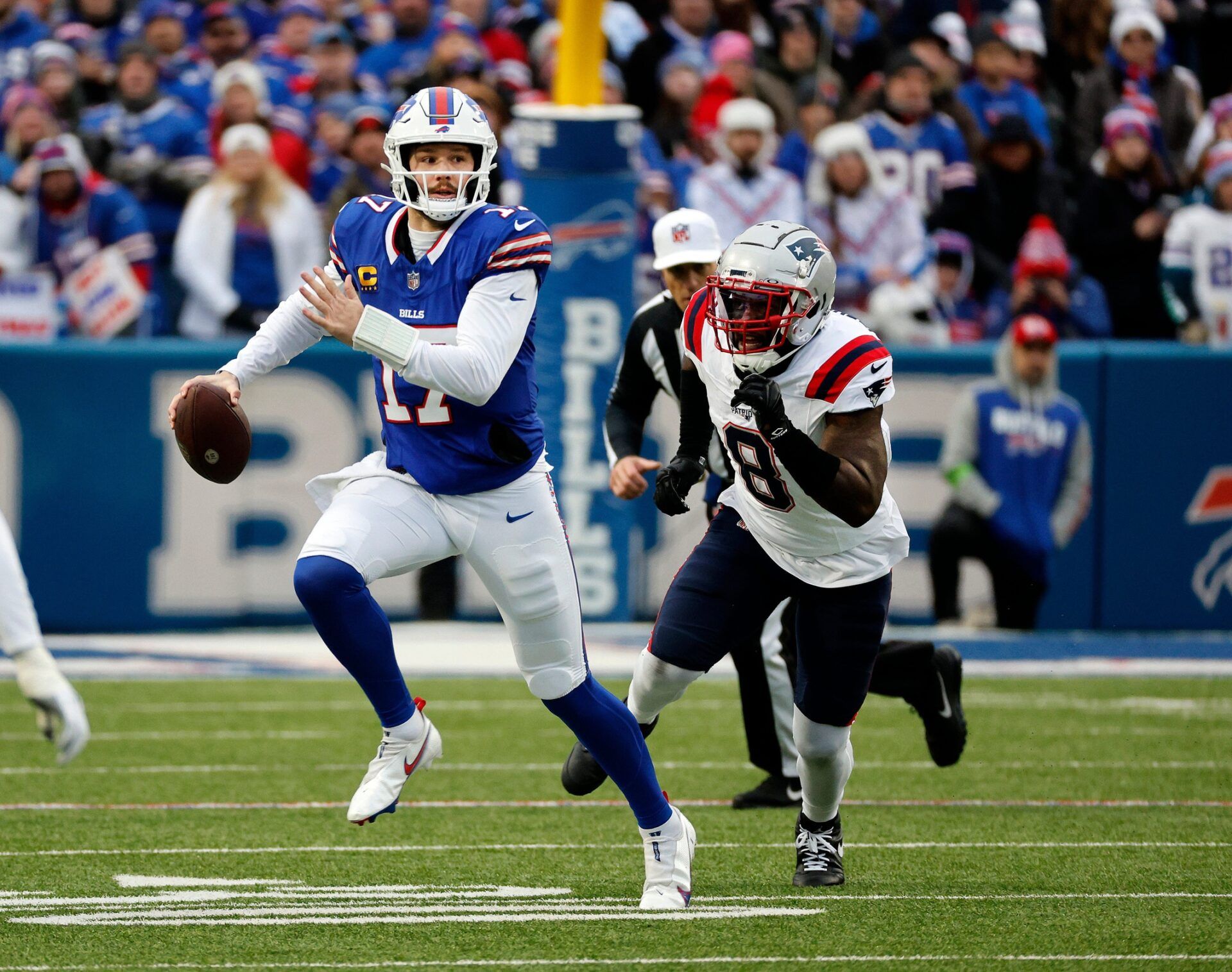 Buffalo Bills quarterback Josh Allen (17) is forced out og the pocket by New England Patriots linebacker Ja'Whaun Bentley (8).