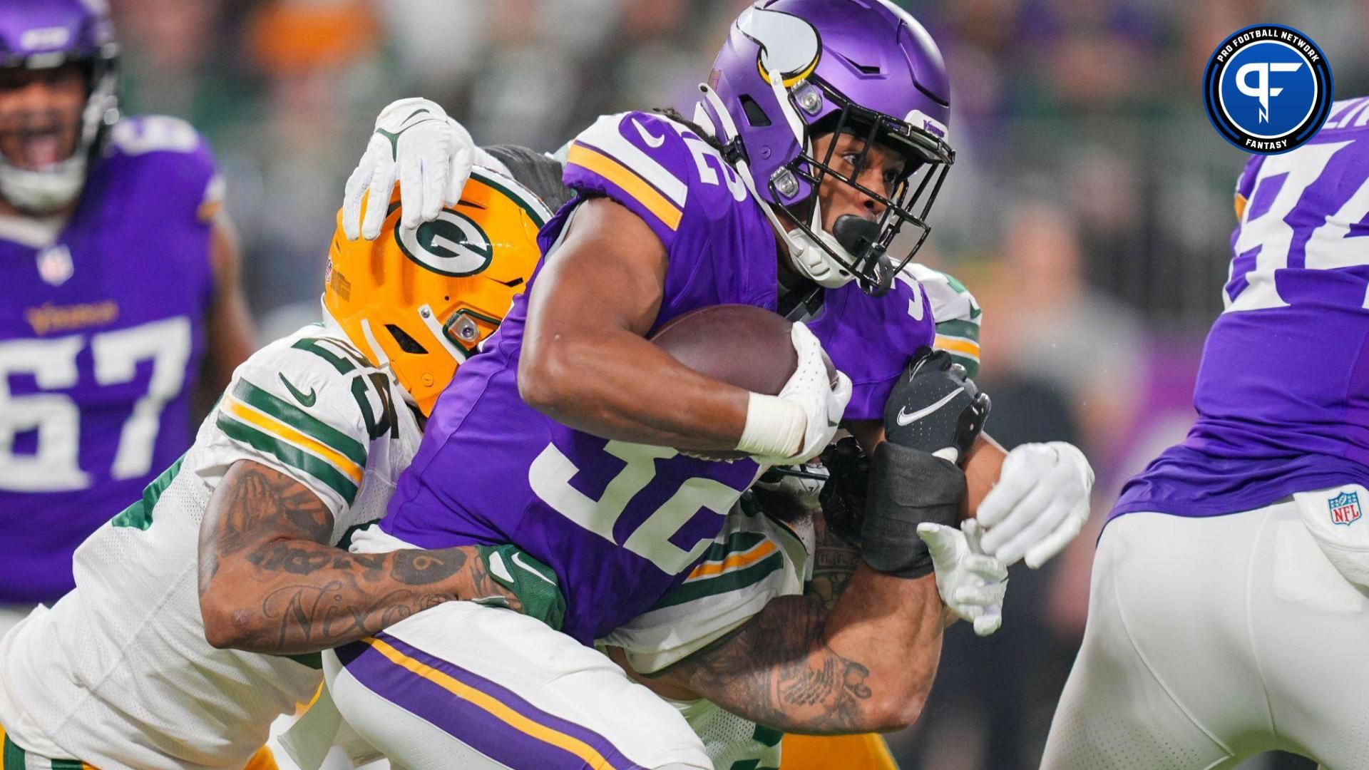 Minnesota Vikings running back Ty Chandler (32) runs with the ball against the Green Bay Packers in the first quarter at U.S. Bank Stadium.