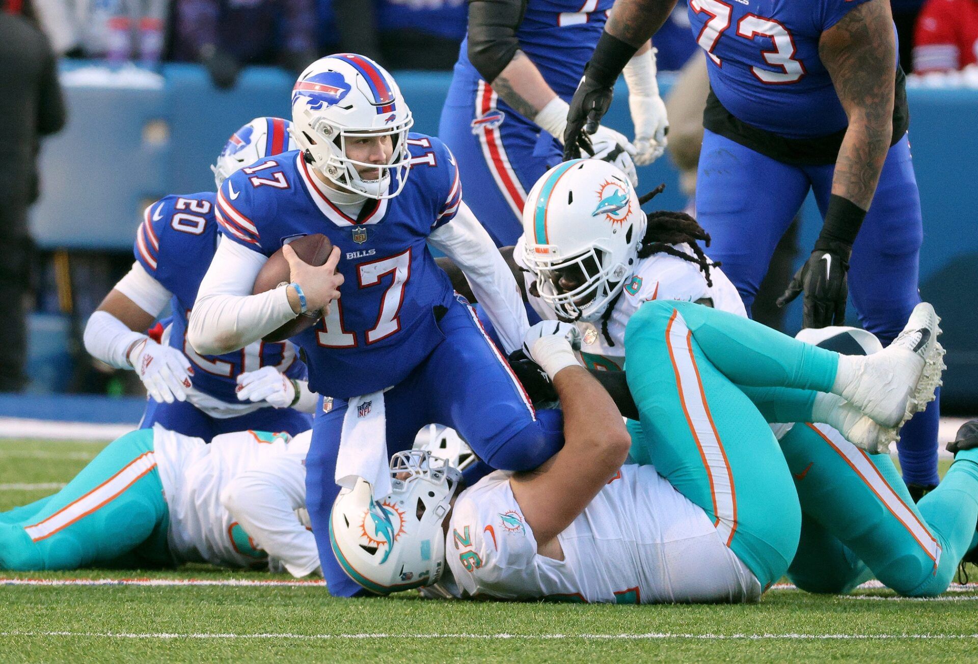 Buffalo Bills QB Josh Allen (17) is tackled by Miami Dolphins defensive players.