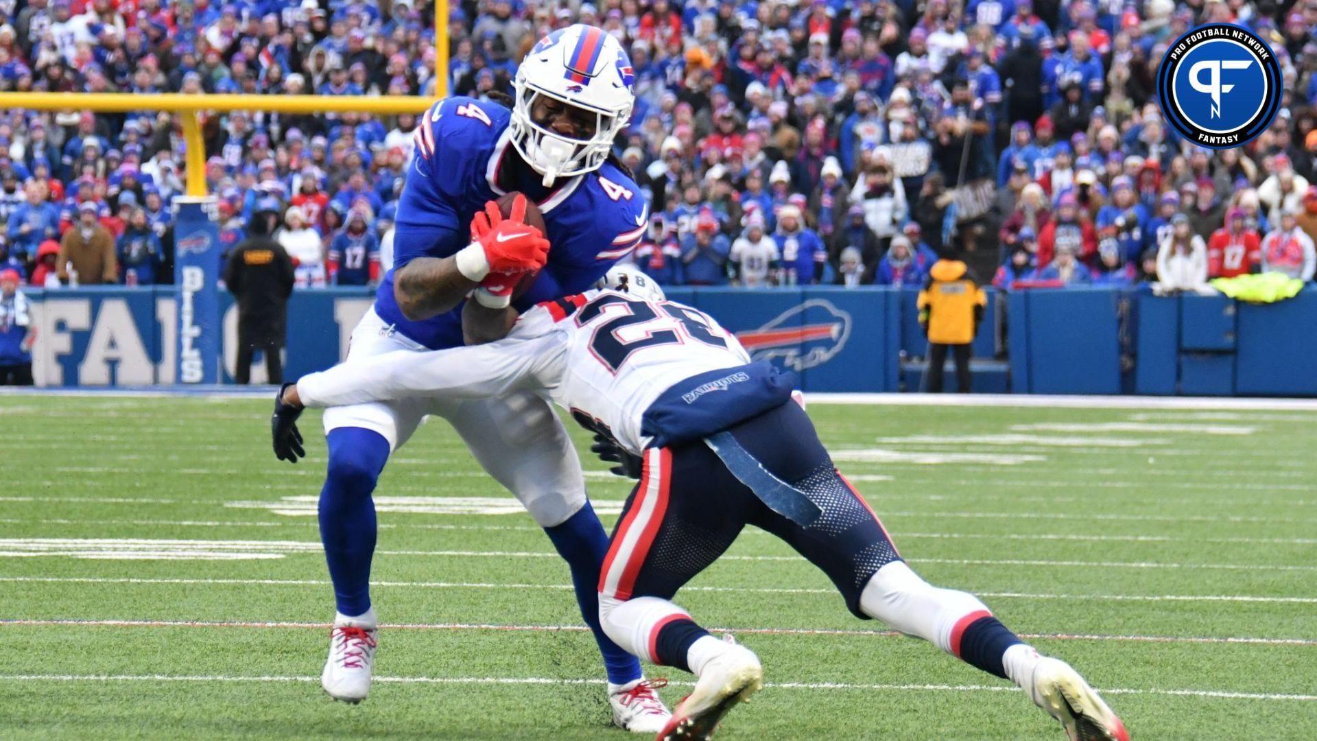 Buffalo Bills running back James Cook (4) is tackled byNew England Patriots cornerback Alex Austin (28) in the first quarter at Highmark Stadium.