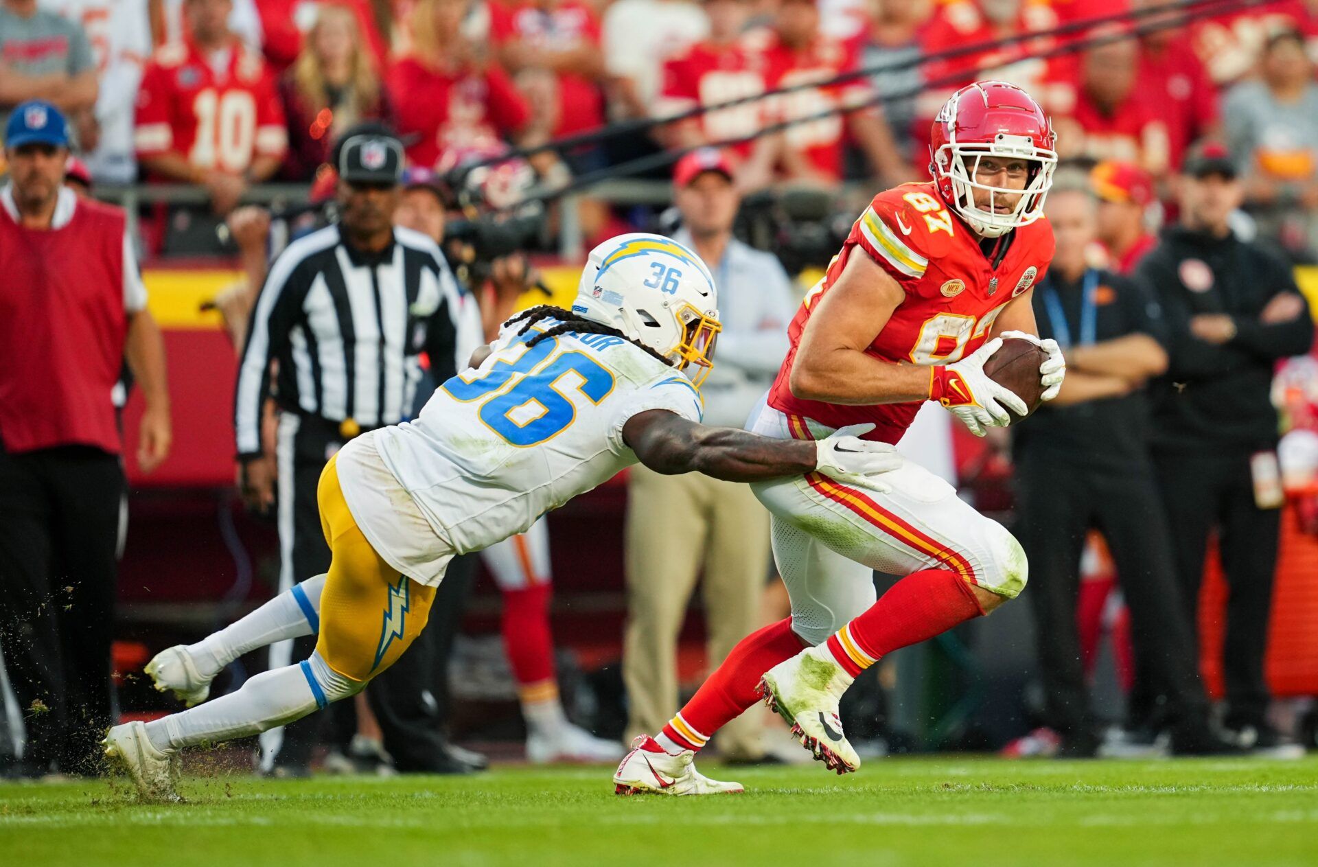 Kansas City Chiefs tight end Travis Kelce (87) runs with the ball against Los Angeles Chargers cornerback Ja'Sir Taylor (36) during the second half at GEHA Field at Arrowhead Stadium.