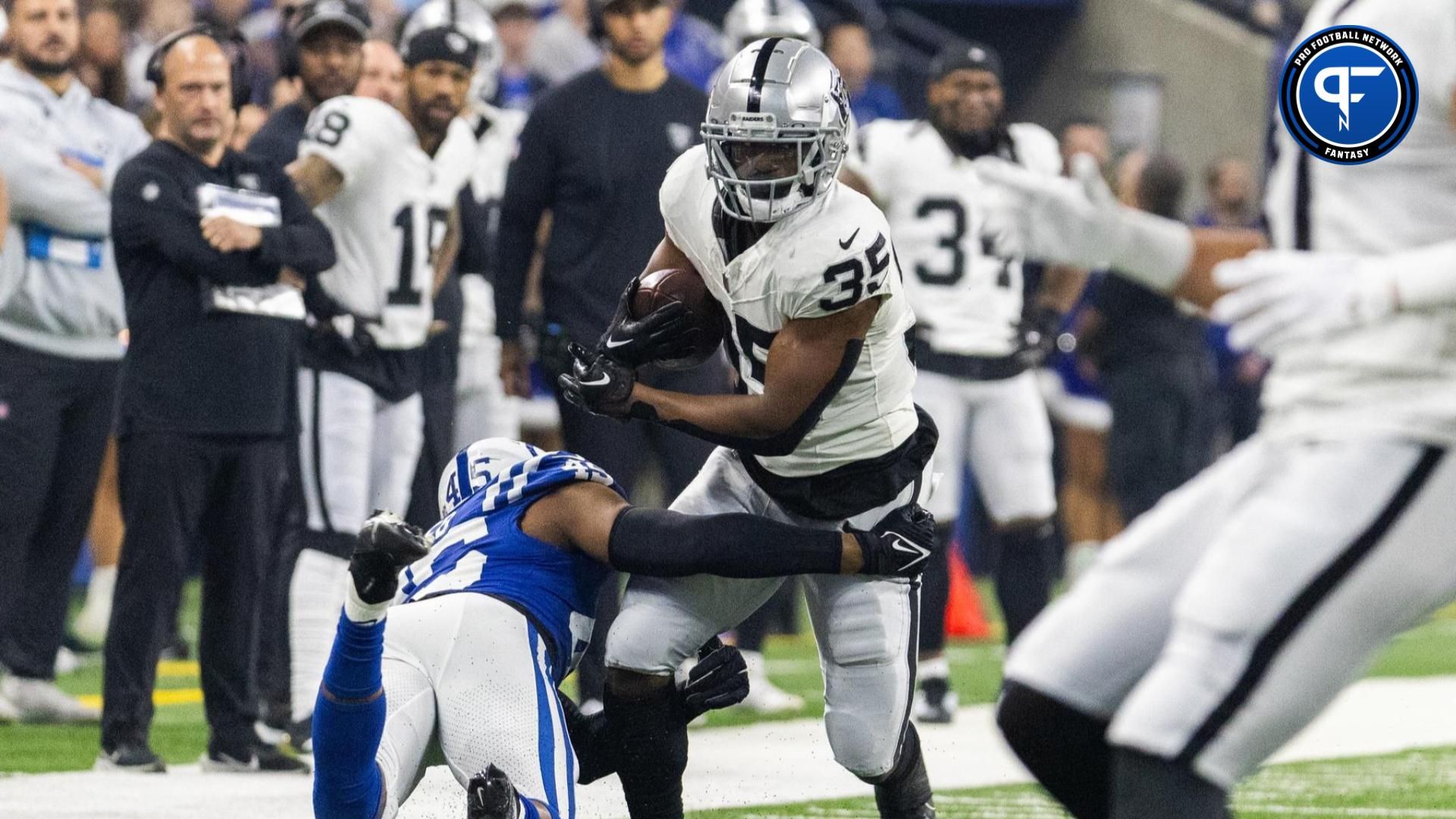 Las Vegas Raiders running back Zamir White (35) runs the ball while Indianapolis Colts linebacker E.J. Speed (45) defends in the first quarter at Lucas Oil Stadium.