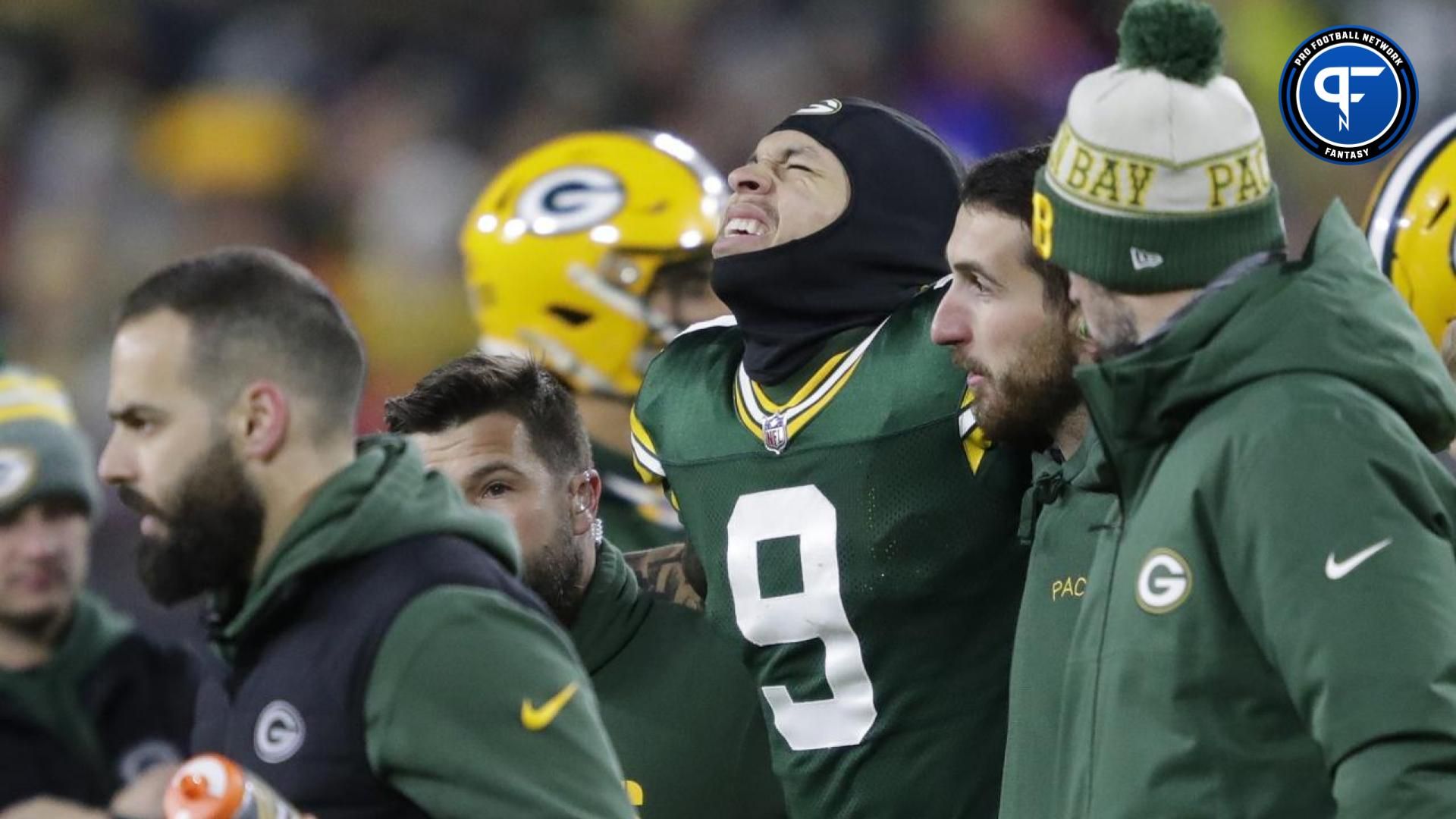 Green Bay Packers wide receiver Christian Watson (9) winces in pain as he is helped off the field after injuring his leg on a first down reception against the Kansas City Chiefs during their football game at Lambeau Field.