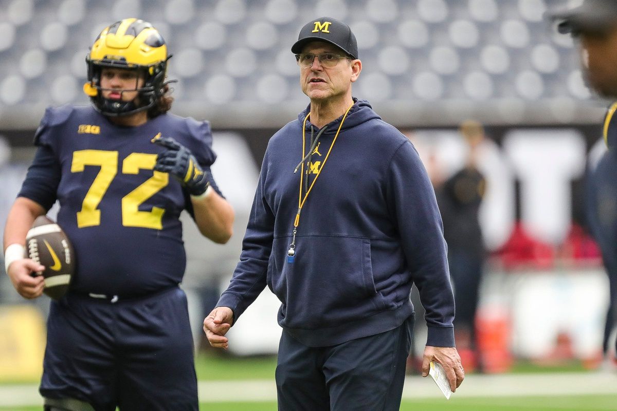 Michigan Wolverines head coach Jim Harbaugh watches warmups during open practice.