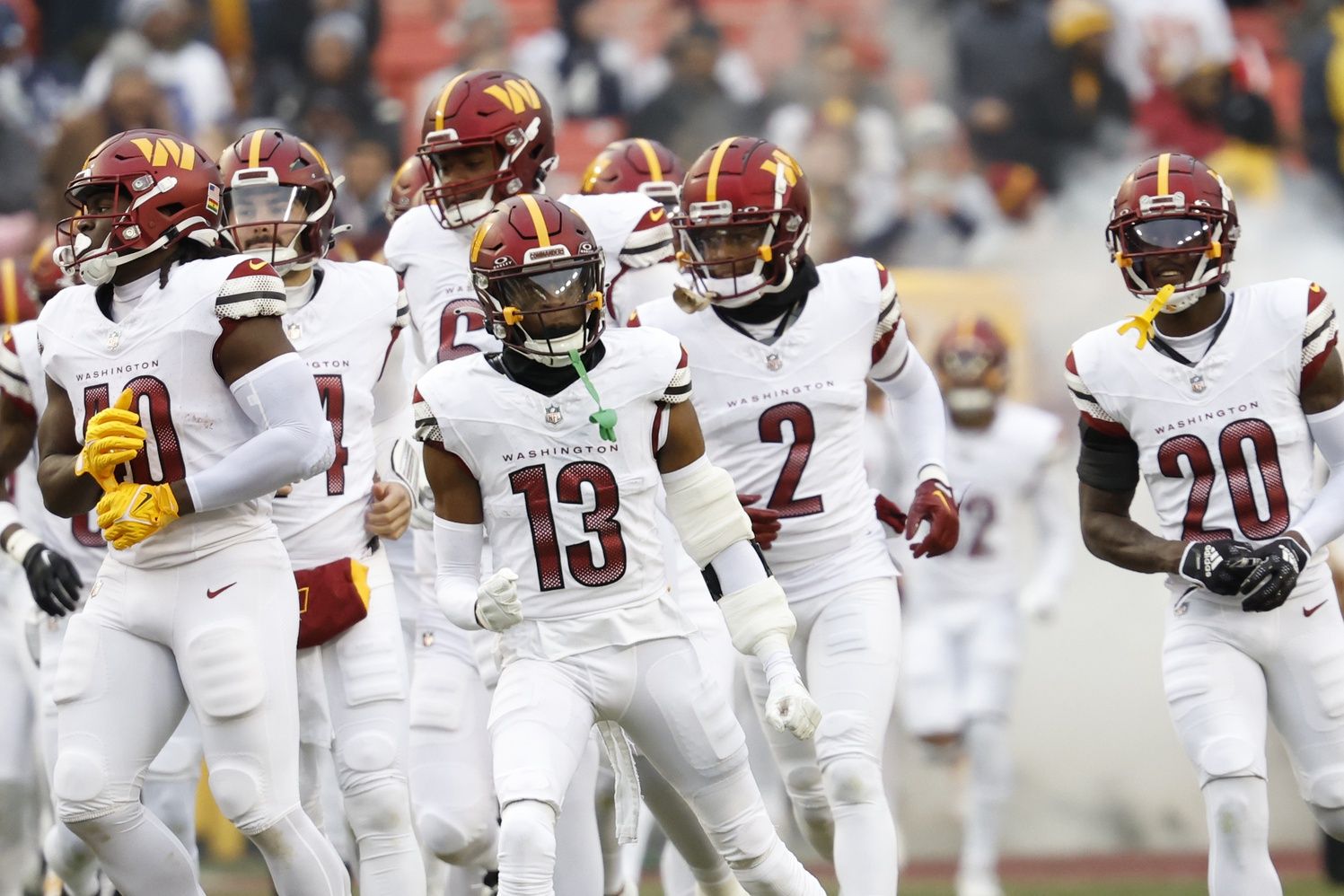 Washington Commanders cornerback Emmanuel Forbes (13) runs onto the field with teammates prior to their game against the Dallas Cowboys at FedExField.