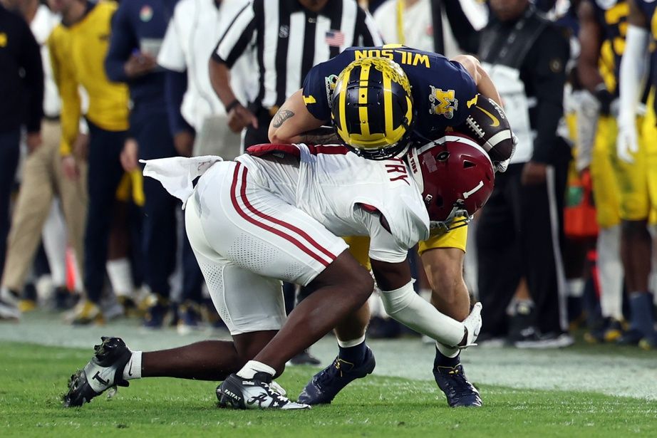 Alabama Crimson Tide DB Kool-Aid McKinstry (1) tackles Michigan Wolverines WR Roman Wilson (1).