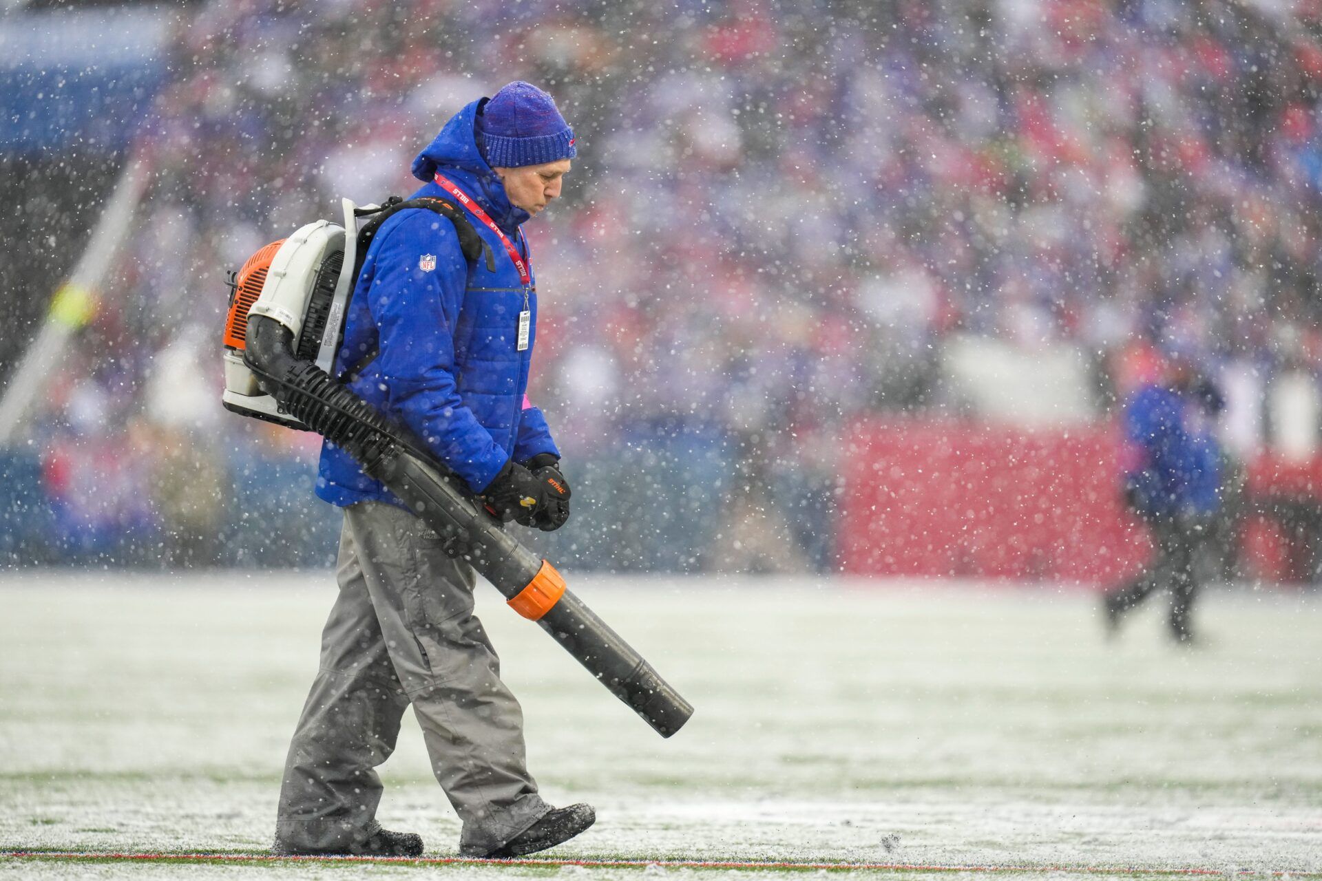 Field crews blow snow off of the yard markers in the first quarter of the NFL divisional playoff football game between the Cincinnati Bengals and the Buffalo Bills.