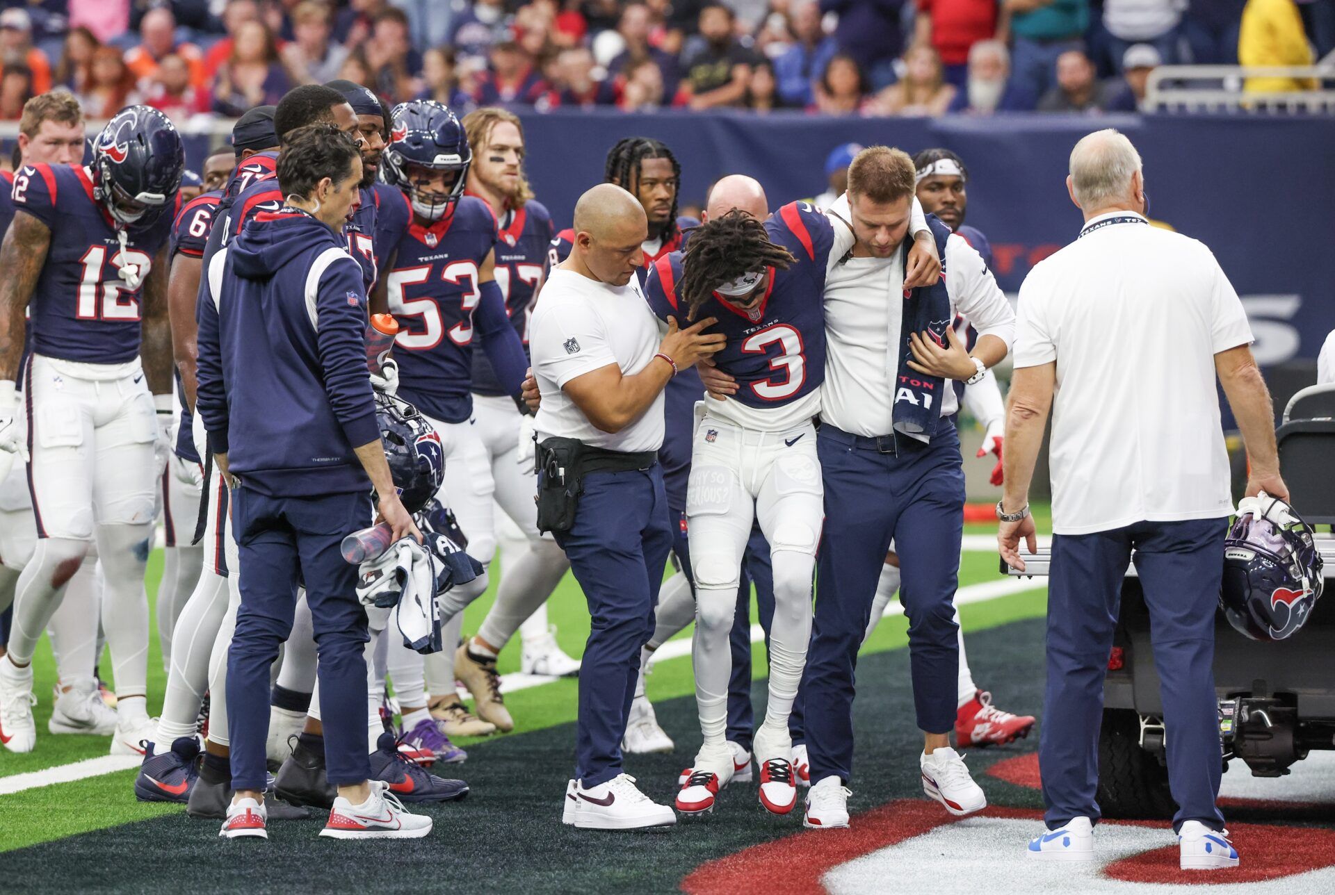 Trainers move an injured Houston Texans wide receiver Tank Dell (3) two the cart as he injured himself on a touchdown play against the Denver Broncos at NRG Stadium.