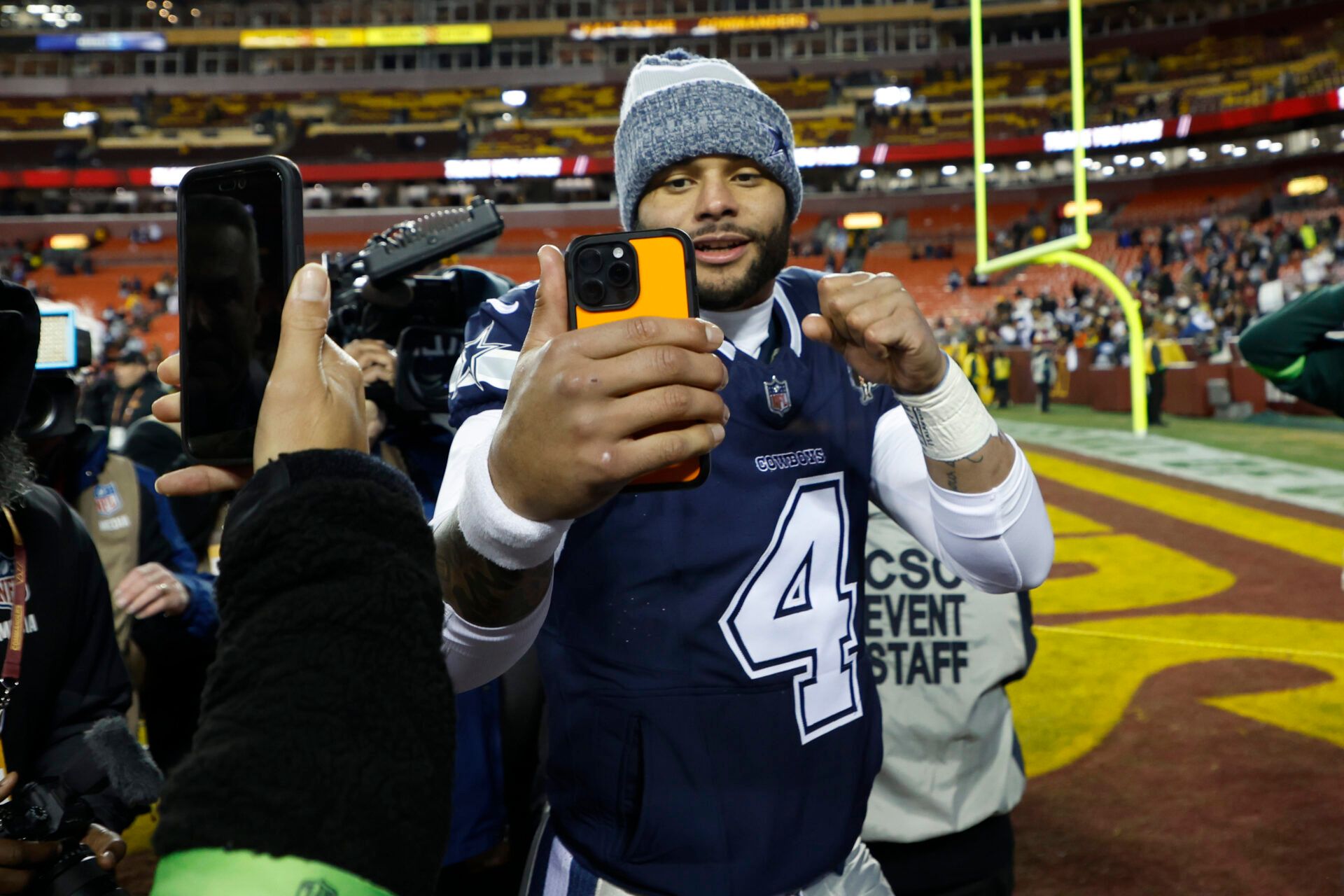 Dallas Cowboys quarterback Dak Prescott (4) records a video while leaving the field after the game against the Washington Commanders at FedExField.