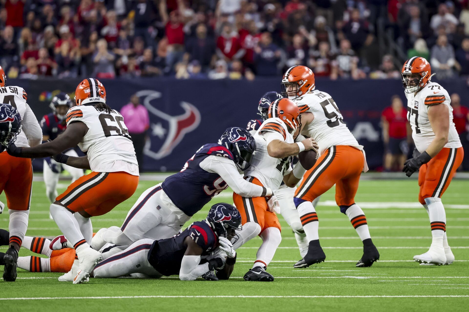 Cleveland Browns quarterback Joe Flacco (15) is sacked by Houston Texans defensive tackle Maliek Collins (96) and Houston Texans defensive end Will Anderson Jr. (51) during the second quarter in a 2024 AFC wild card game at NRG Stadium.