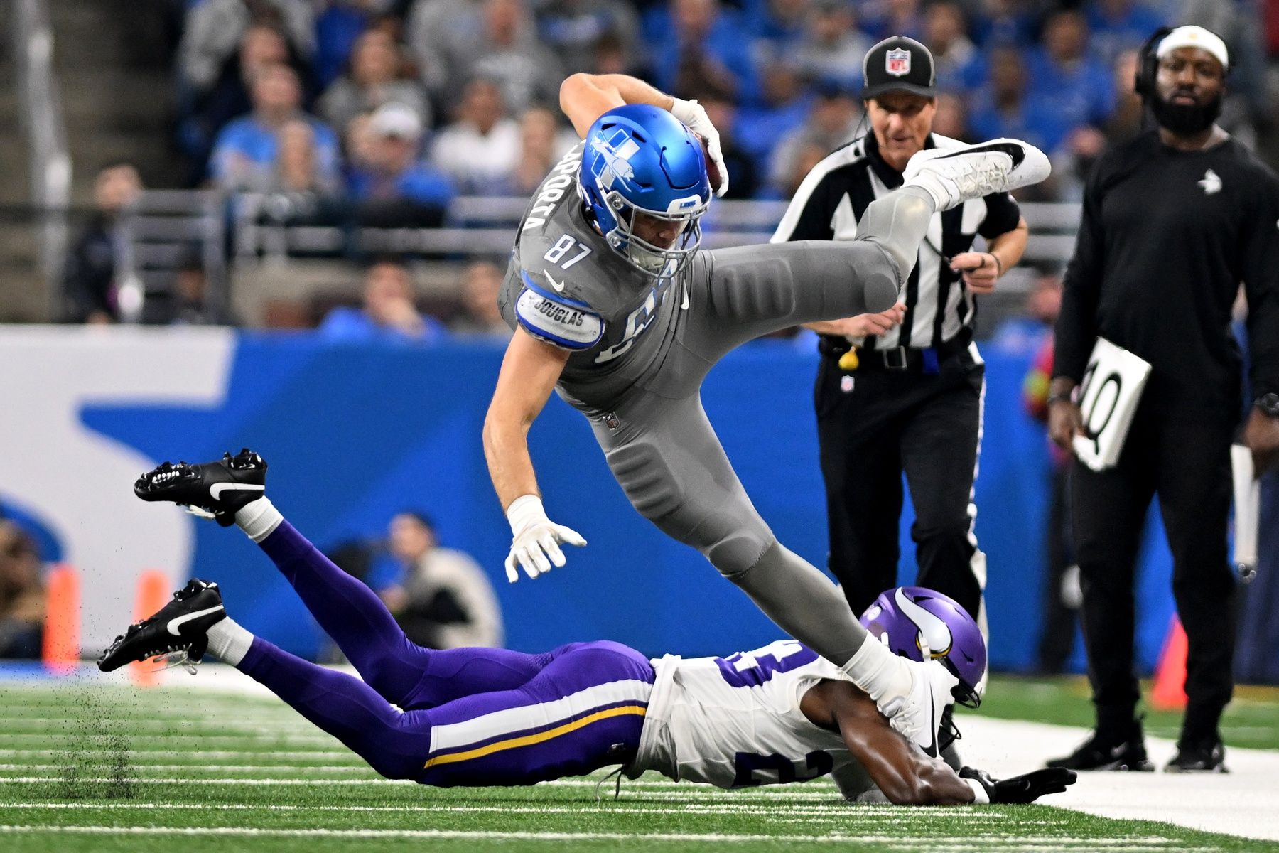 Detroit Lions TE Sam LaPorta (87) gets tackled by Minnesota Vikings CB Andrew Booth Jr. (23).