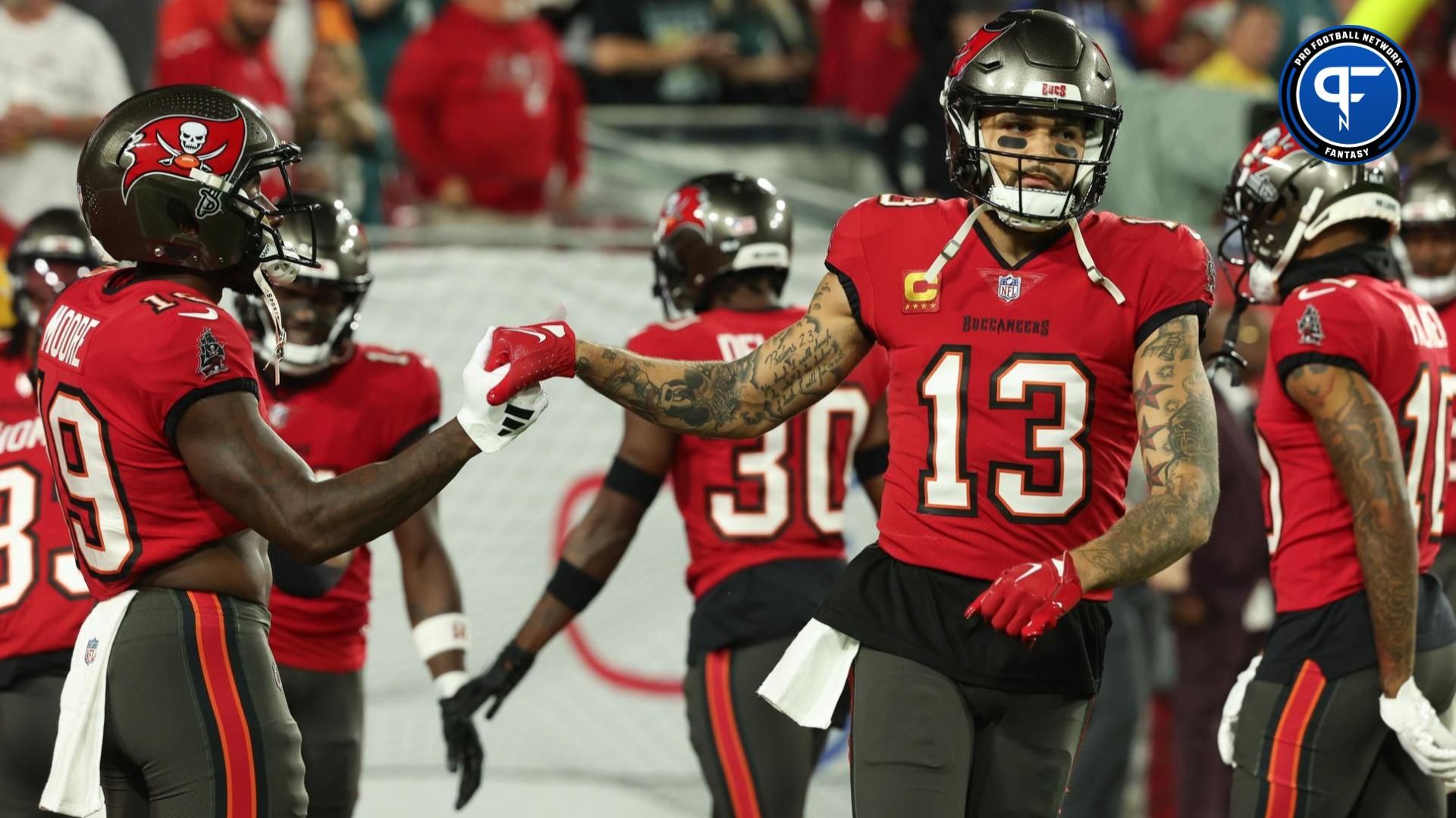 Tampa Bay Buccaneers wide receiver Mike Evans (13) greets wide receiver David Moore (19) during warm ups before a 2024 NFC wild card game against the Philadelphia Eagles at Raymond James Stadium.