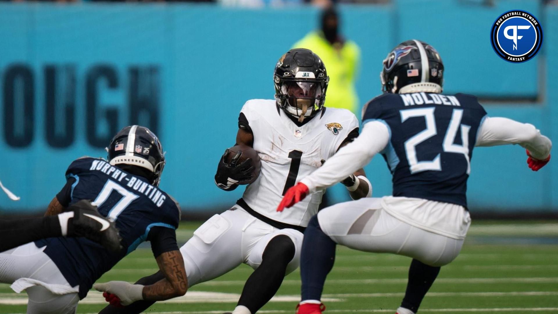 Jacksonville Jaguars running back Travis Etienne Jr. (1) is bottled-up for a loss by Tennessee Titans cornerback Elijah Molden (24) during their game at Nissan Stadium in Nashville, Tenn., Sunday, Jan. 7, 2024.