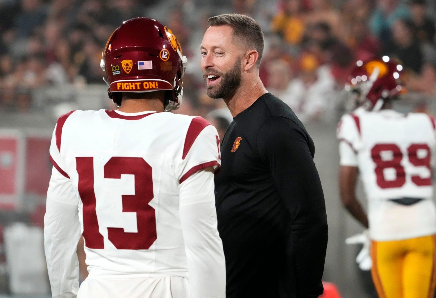 The former Arizona Cardinals head coach and now USC Trojans assistant coach Kliff Kingsbury talks to quarterback Caleb Williams (13) during the pregame warmup before playing the Arizona State Sun Devils at Mountain America Stadium.