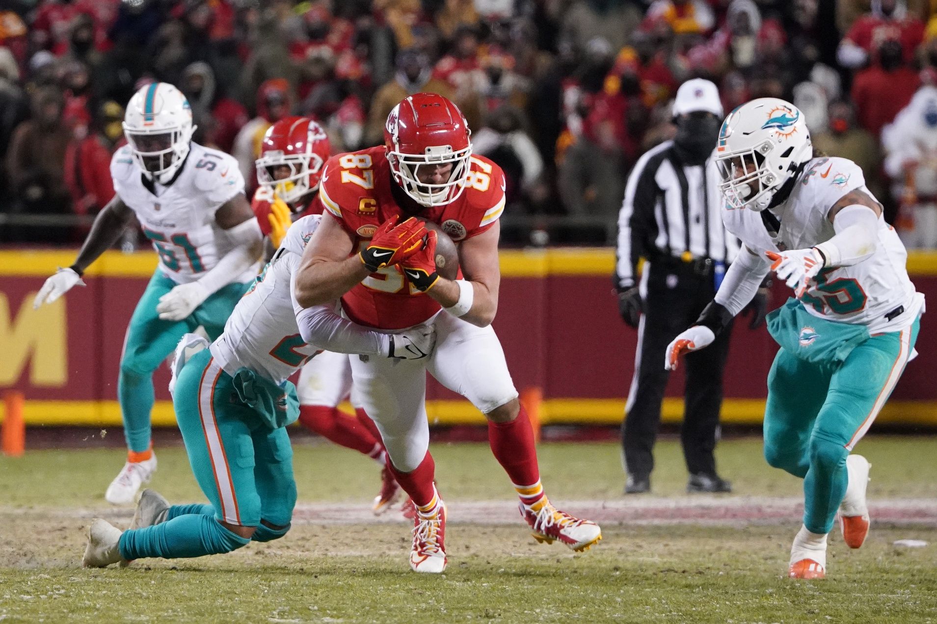 Kansas City Chiefs tight end Travis Kelce (87) runs the ball against the Miami Dolphins during the first half of the 2024 AFC wild card game at GEHA Field at Arrowhead Stadium.