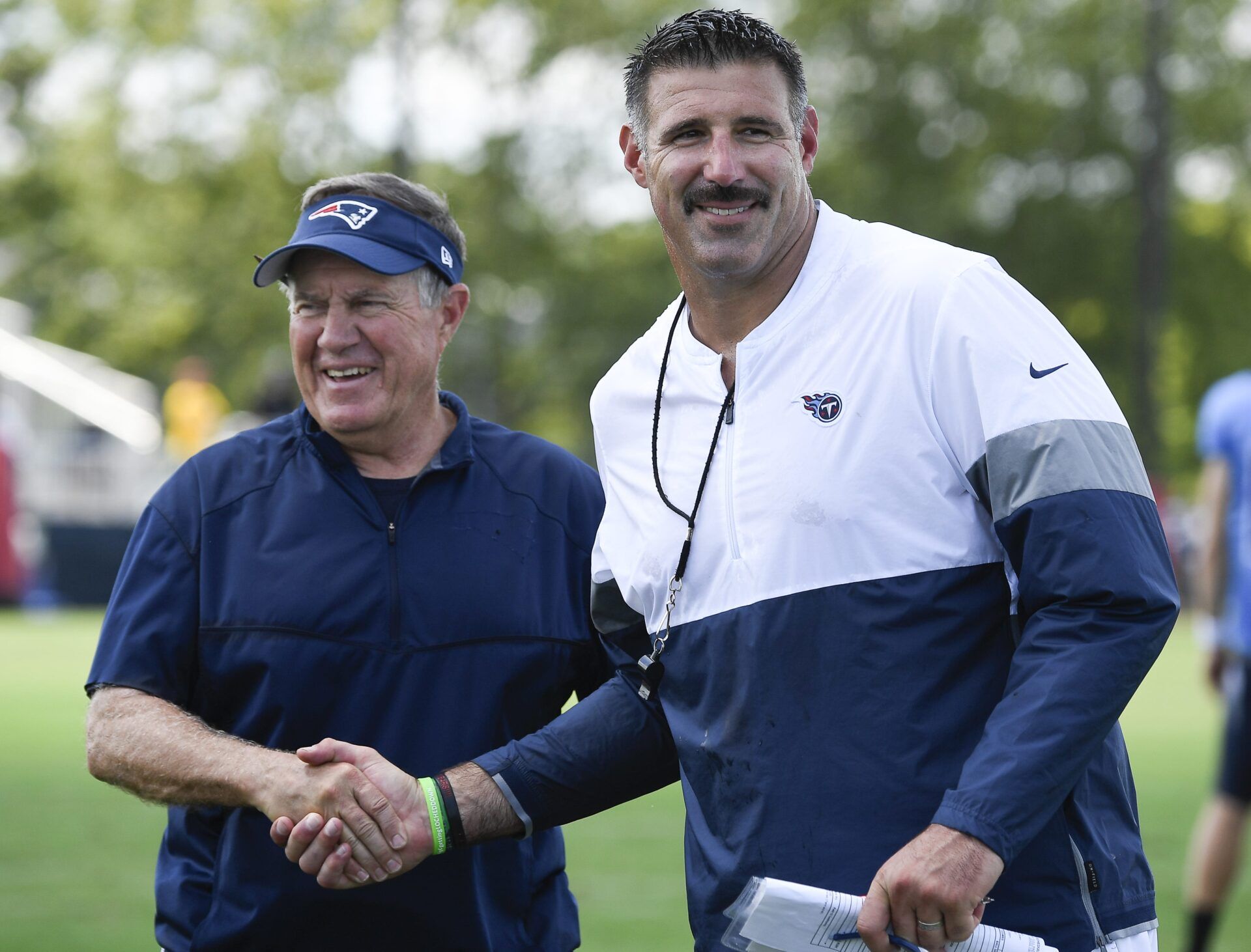 New England Patriots head coach Bill Belichick, left, shares a laugh with Tennessee Titans head coach Mike Vrabel after a joint training camp practice at Saint Thomas Sports Park Aug. 14, 2019 in Nashville.