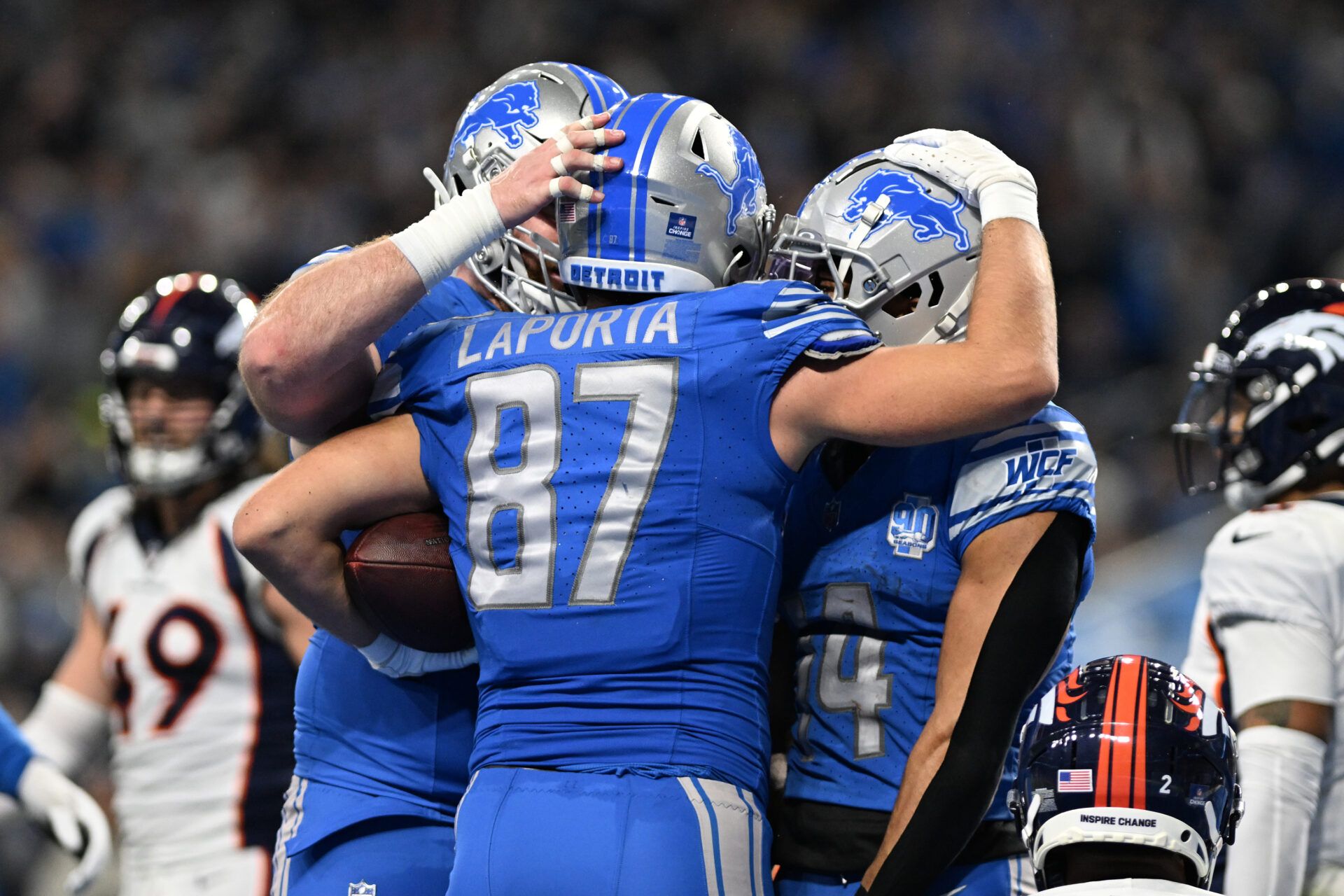 Detroit Lions tight end Sam LaPorta (87) celebrates with wide receiver Amon-Ra St. Brown (14) and center Frank Ragnow (77) after scoring a touchdown against the Denver Broncos in the third quarter at Ford Field.