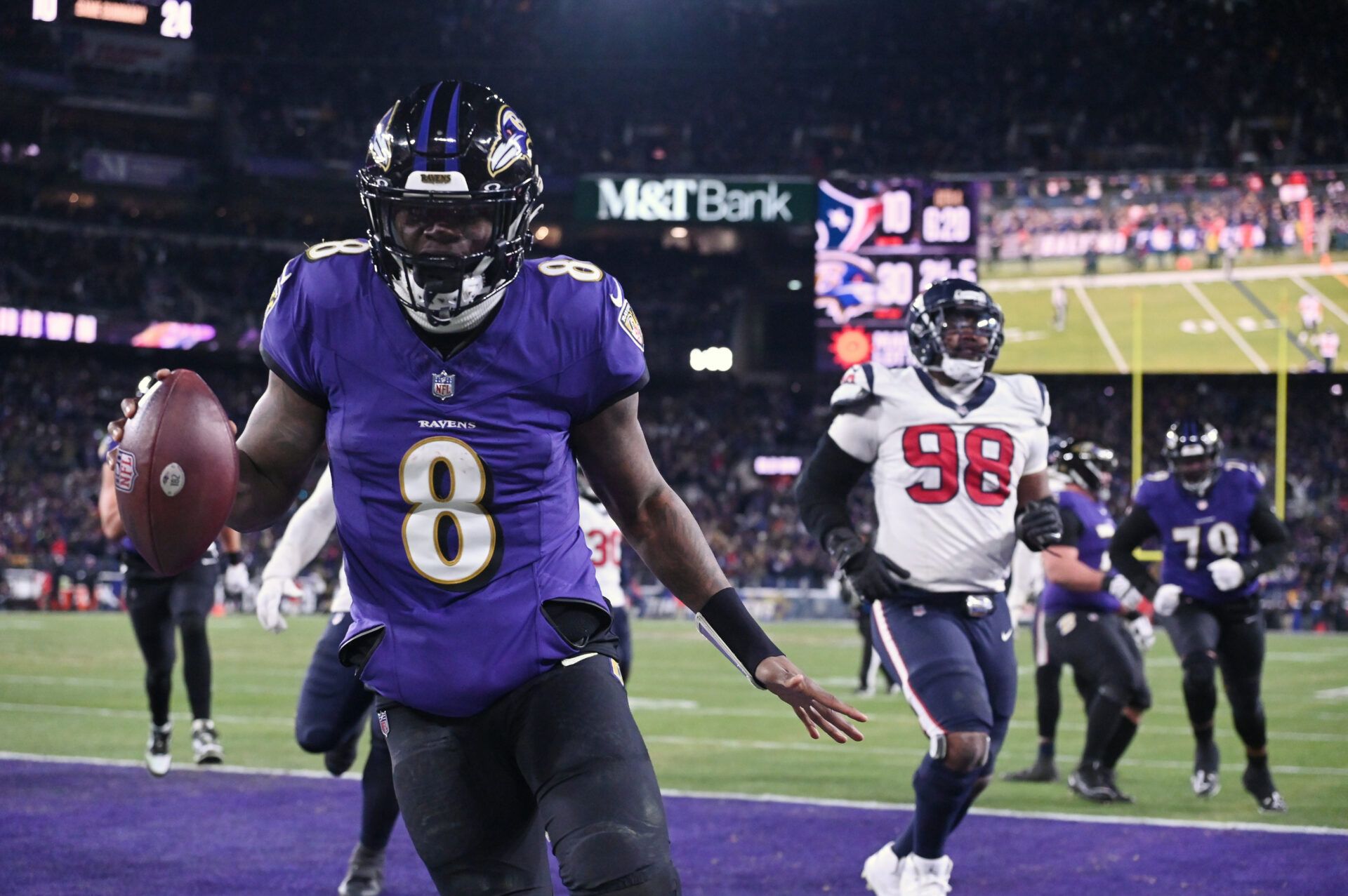 Baltimore, MD, USA; Baltimore Ravens quarterback Lamar Jackson (8) runs the ball to score a touchdown against Houston Texans defensive tackle Sheldon Rankins (98) during the fourth quarter of a 2024 AFC divisional round game at M&T Bank Stadium.