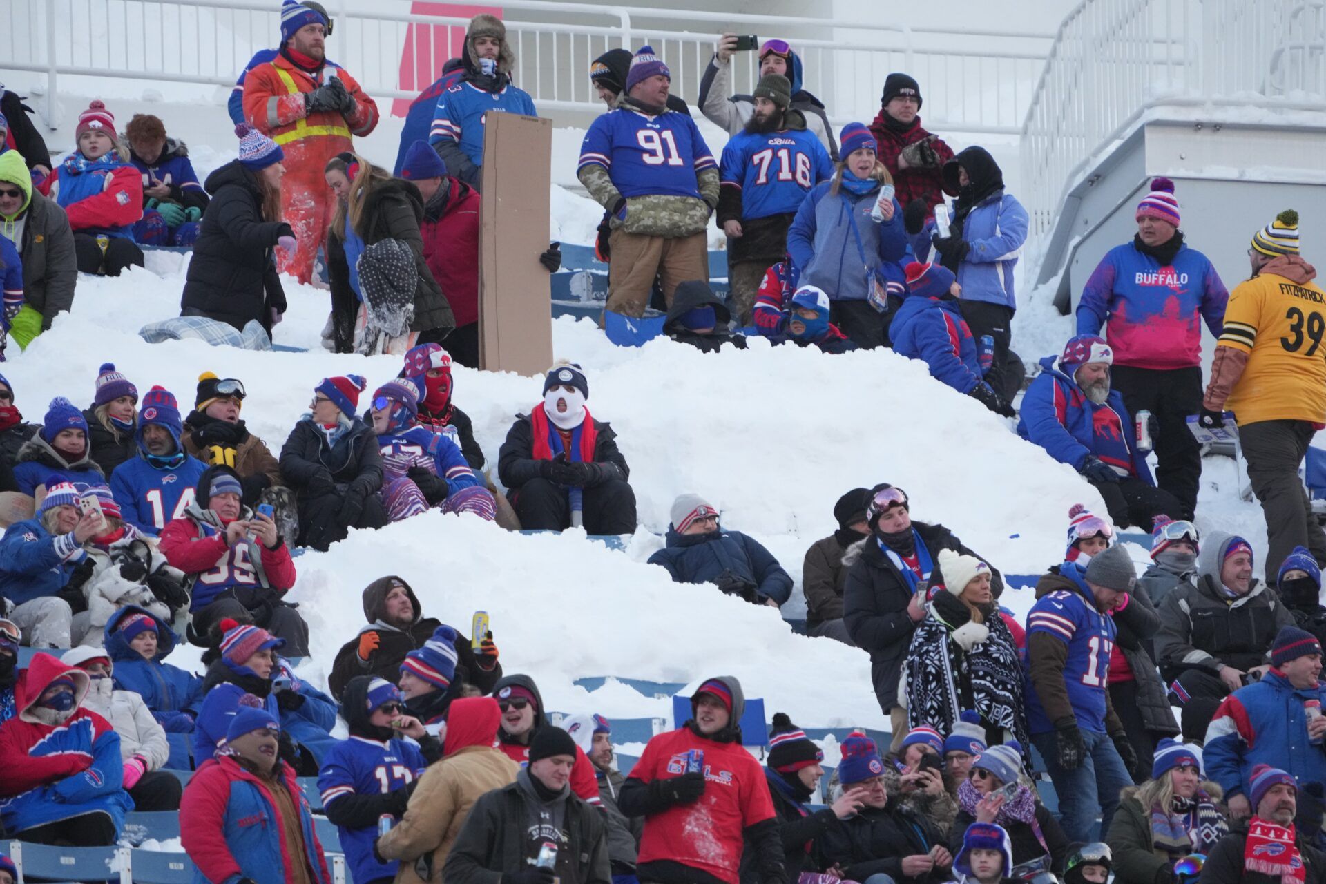 Buffalo Bills fans sit in snow before the game against the Pittsburgh Steelers in a 2024 AFC wild card game at Highmark Stadium.