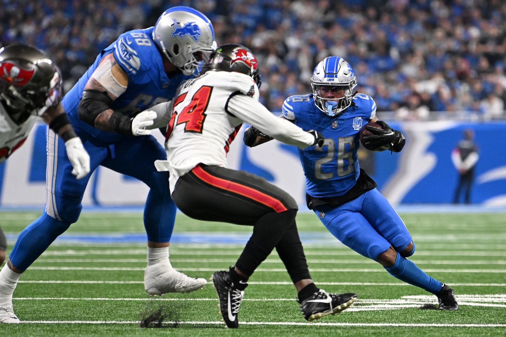 Detroit Lions running back Jahmyr Gibbs (26) runs with the ball against the Tampa Bay Buccaneers during the second quarter in a 2024 NFC divisional round game at Ford Field.