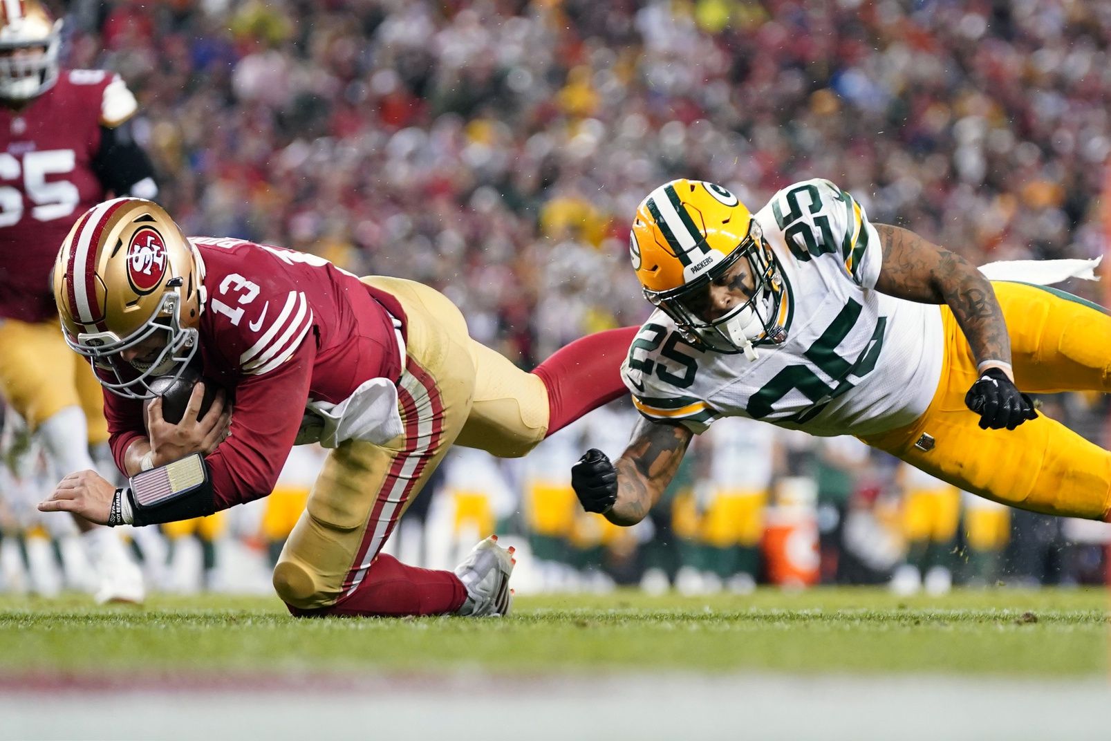 San Francisco 49ers quarterback Brock Purdy (13) runs against Green Bay Packers cornerback Keisean Nixon (25) during the fourth quarter in a 2024 NFC divisional round game at Levi's Stadium.