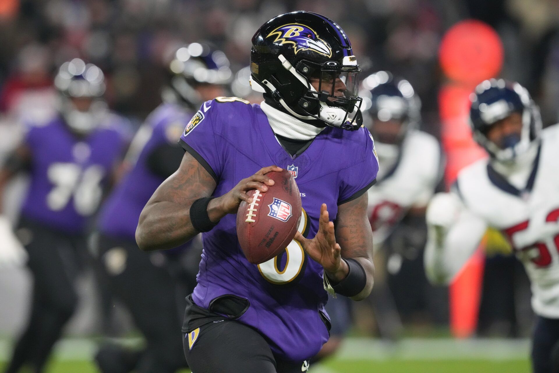 Baltimore Ravens quarterback Lamar Jackson (8) rolls out to throw against the Houston Texans during the second quarter of a 2024 AFC divisional round game at M&T Bank Stadium.