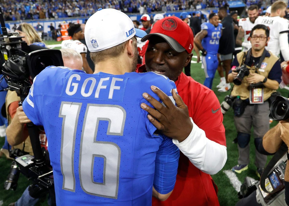 Detroit Lions quarterback Jared Goff and Tampa Bay Buccaneers head coach Todd Bowles hug at midfield at the end of the NFC Divisional Playoff at Ford Field.