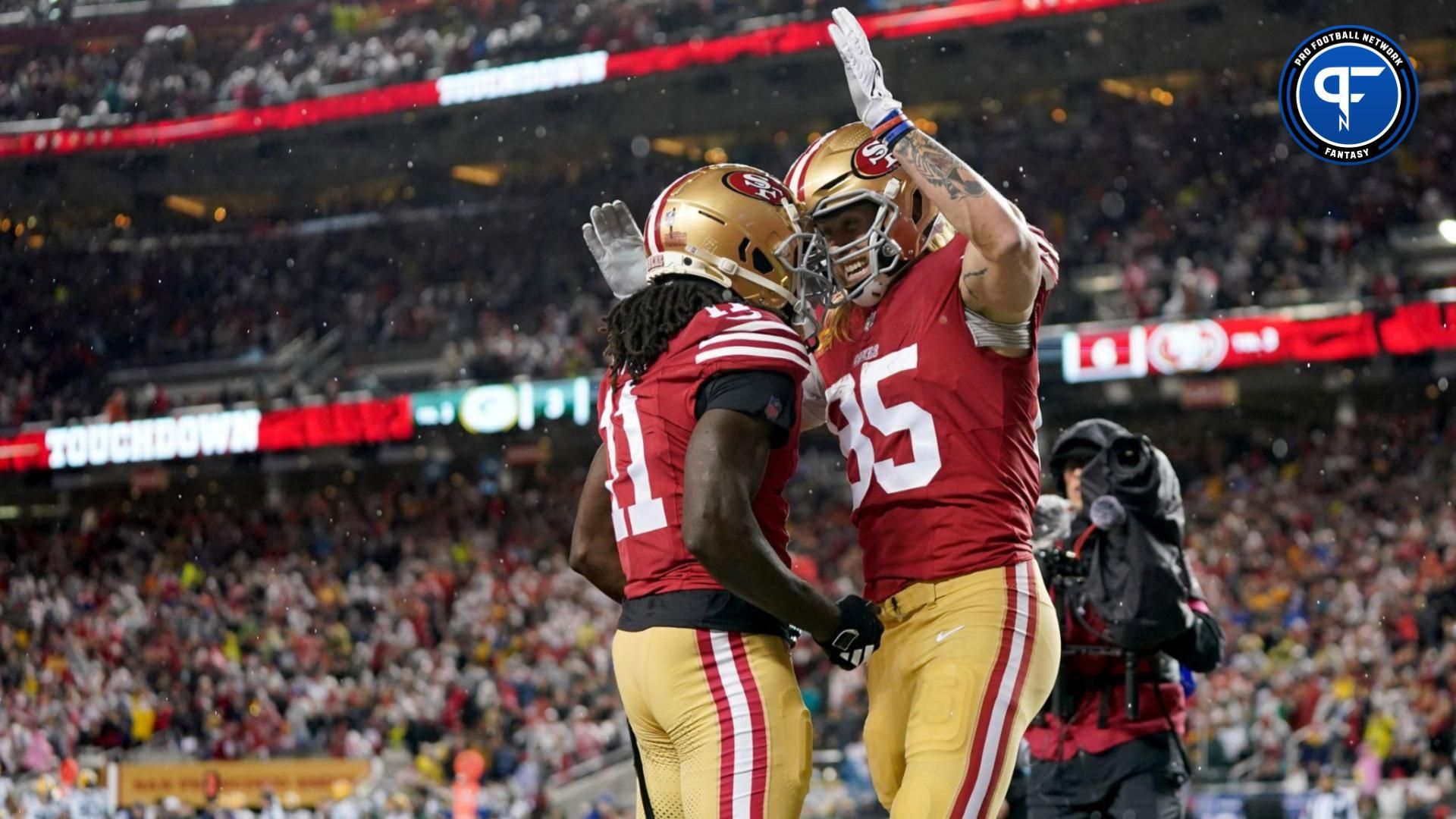 San Francisco 49ers tight end George Kittle (85) celebrates with wide receiver Brandon Aiyuk (11) after scoring a touchdown against the Green Bay Packers during the second quarter in a 2024 NFC divisional round game at Levi's Stadium.