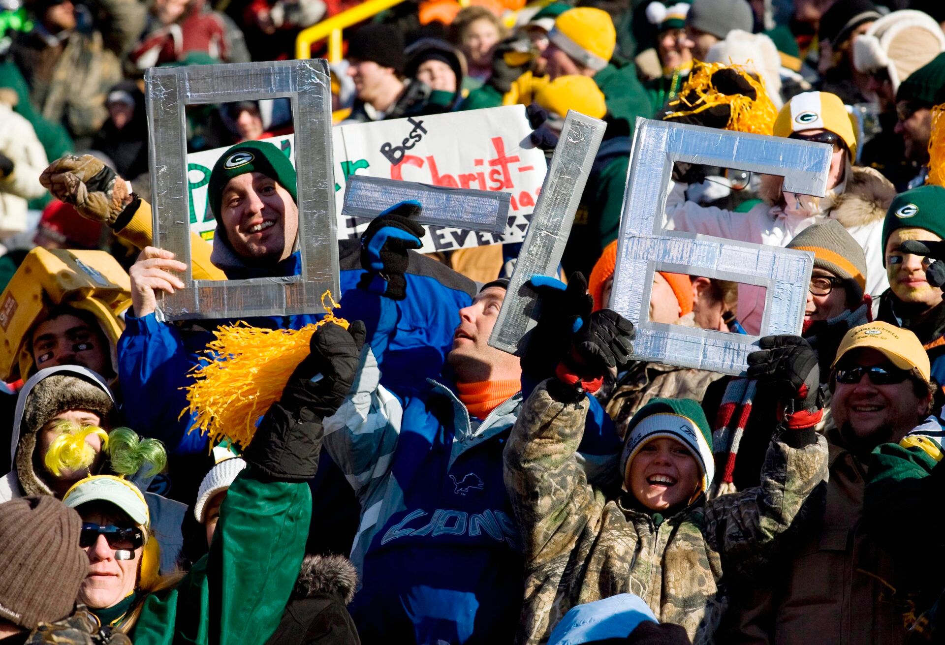 Fans hold up signs celebrating the Detroit Lions 0-16 season during the game against the Green Bay Packers at Lambeau Field.