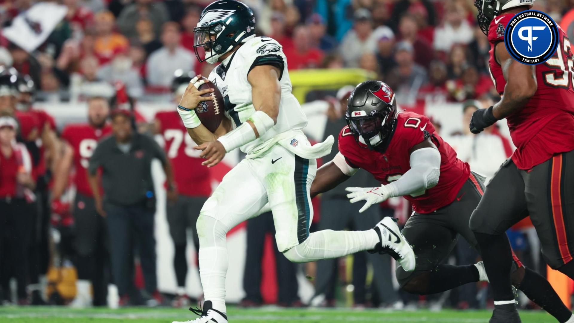 Philadelphia Eagles quarterback Jalen Hurts (1) evades Tampa Bay Buccaneers linebacker Yaya Diaby (0) during the second half of a 2024 NFC wild card game at Raymond James Stadium.