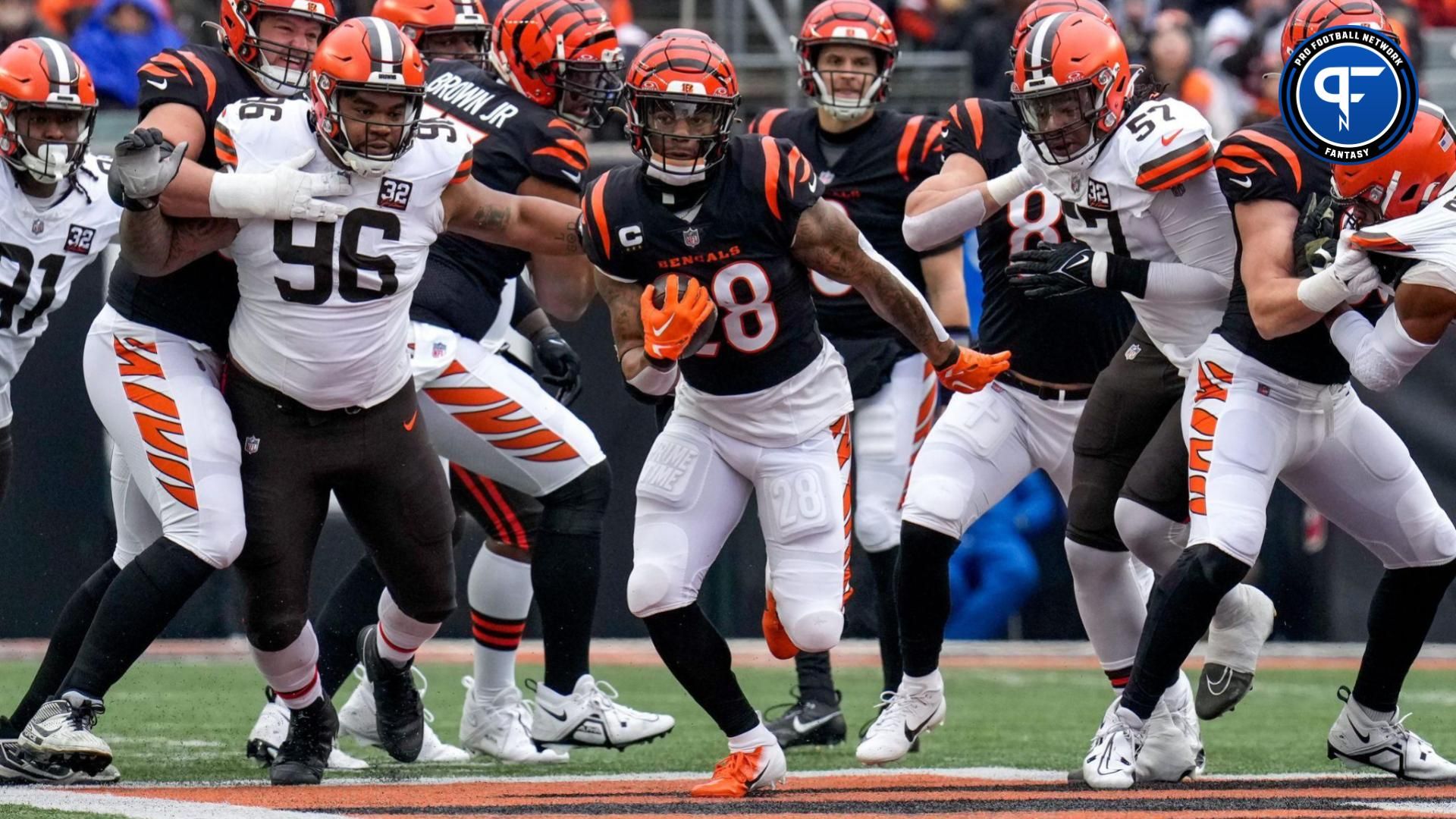 Cincinnati Bengals running back Joe Mixon (28) breaks through the line on a carry in the first quarter of the NFL Week 18 game between the Cincinnati Bengals and the Cleveland Browns at Paycor Stadium in downtown Cincinnati on Sunday, Jan. 7, 2024.