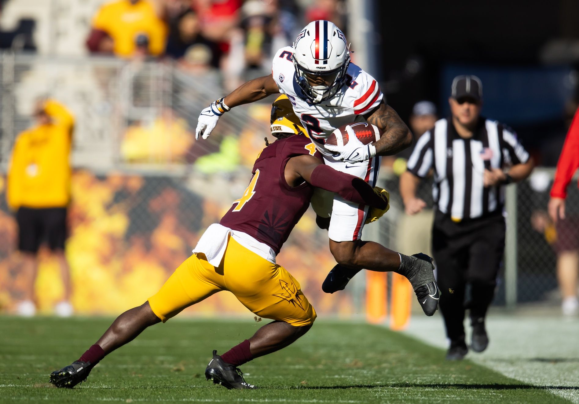 Arizona Wildcats running back Jacob Cowing (2) is tackled by Arizona State Sun Devils defensive back Demetries Ford (4) in the first half of the Territorial Cup at Mountain America Stadium.