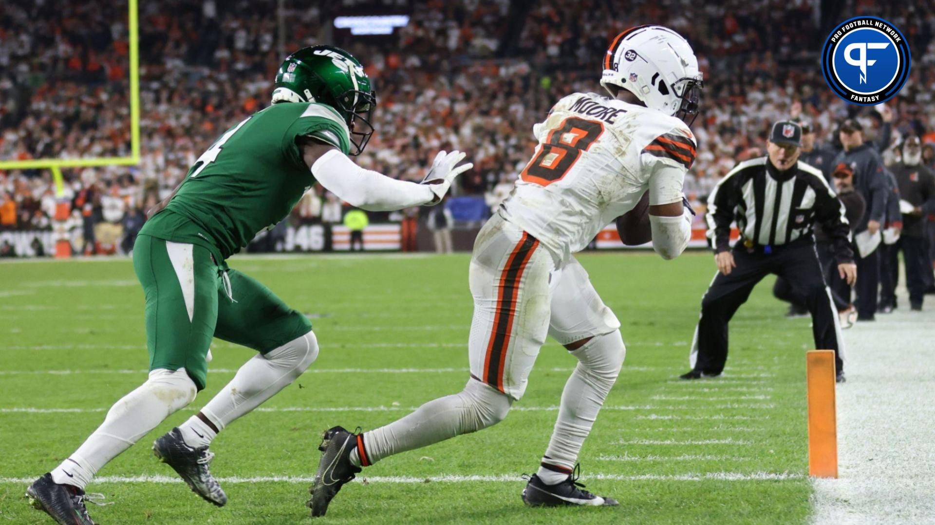 Cleveland Browns wide receiver Elijah Moore (8) catches a touchdown pass ahead of New York Jets cornerback D.J. Reed (4) during the first half at Cleveland Browns Stadium.