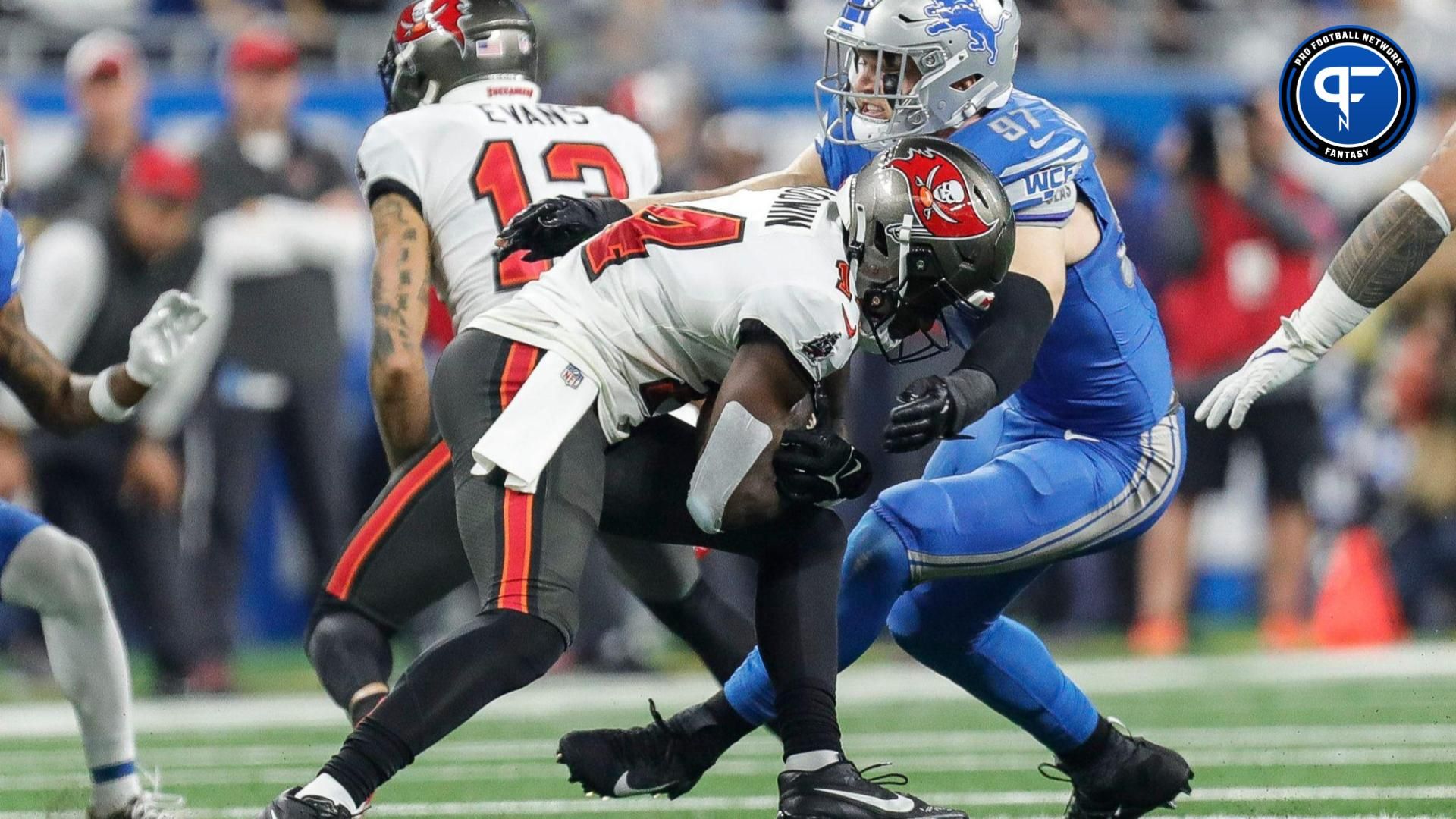 Detroit Lions defensive end Aidan Hutchinson (97) tackles Tampa Bay Buccaneers wide receiver Chris Godwin (14) during the first half of the NFC divisional round at Ford Field