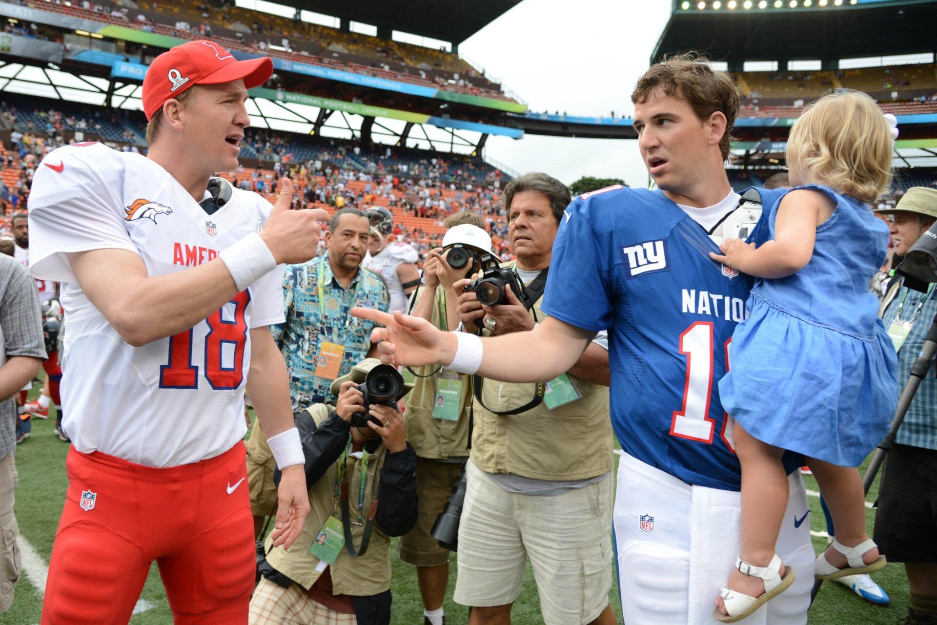 AFC quarterback Peyton Manning of the Denver Broncos (18, left) shakes hands with NFC quarterback Eli Manning of the New York Giants (10, right) after the 2013 Pro Bowl at Aloha Stadium. The NFC defeated the AFC 62-35.