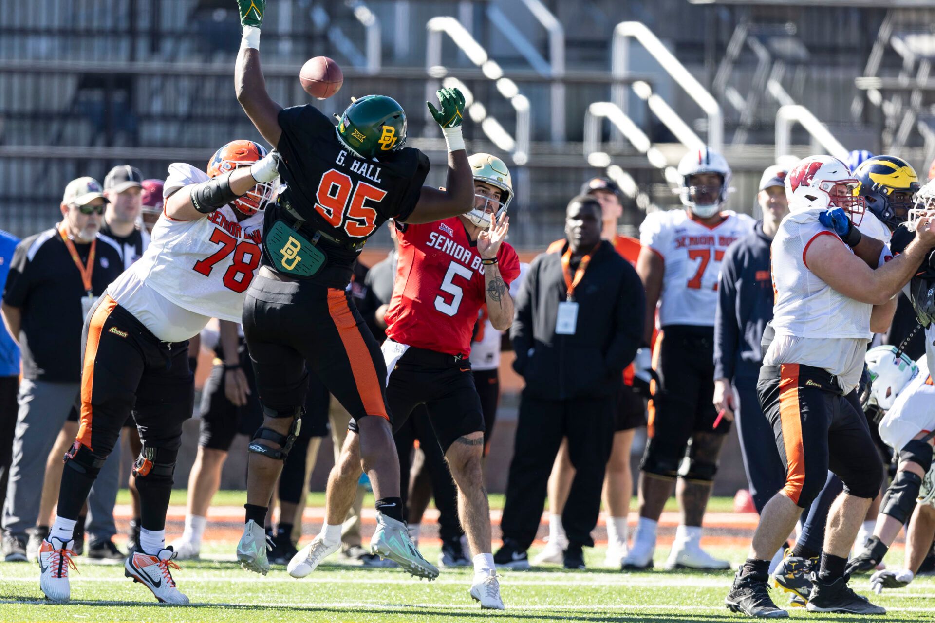 National offensive lineman Isaiah Adams of Illinois (78) blocks National defensive lineman Gabe Hall of Baylor (95) as National quarterback Sam Hartman of Notre Dame (5) throws during practice for the National team at Hancock Whitney Stadium.