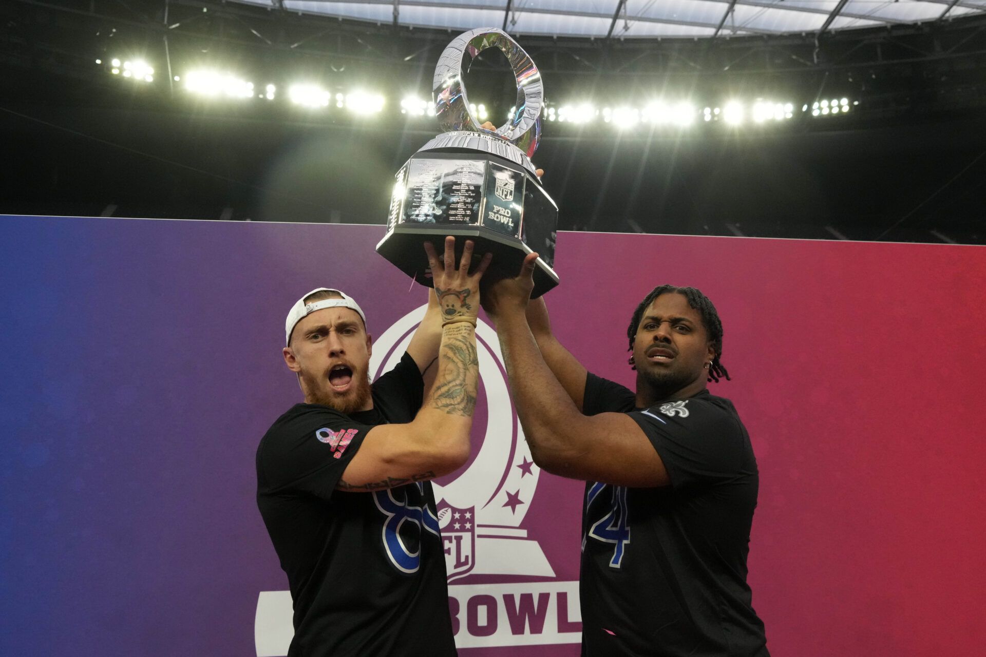 NFC tight end George Kittle of the San Francisco 49ers (85) and NFC defensive end Cameron Jordan of the New Orleans Saints (94) pose with trophy during the Pro Bowl Games at Allegiant Stadium.