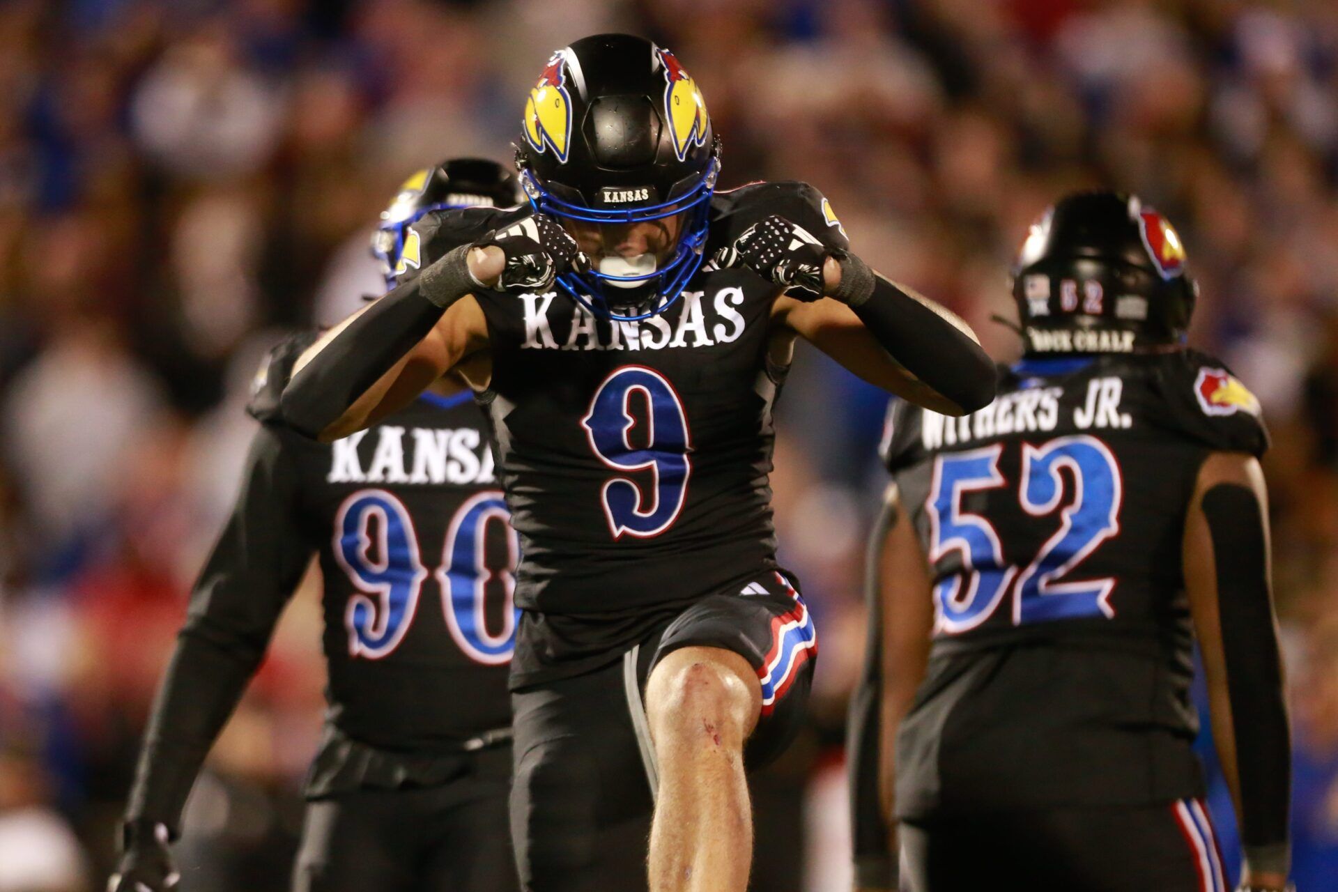 Kansas redshirt sophomore defensive lineman Austin Booker (9) reacts after a sack in the fourth quarter of Saturday's Sunflower Showdown against Kansas State.