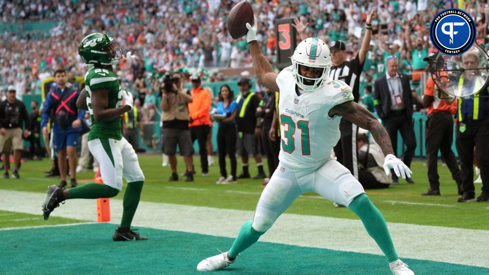 Miami Dolphins running back Raheem Mostert (31) spikes the ball after scoring a touchdown past New York Jets safety Tony Adams (22) during the first half of an NFL game at Hard Rock Stadium in Miami Gardens, Dec. 17, 2023.