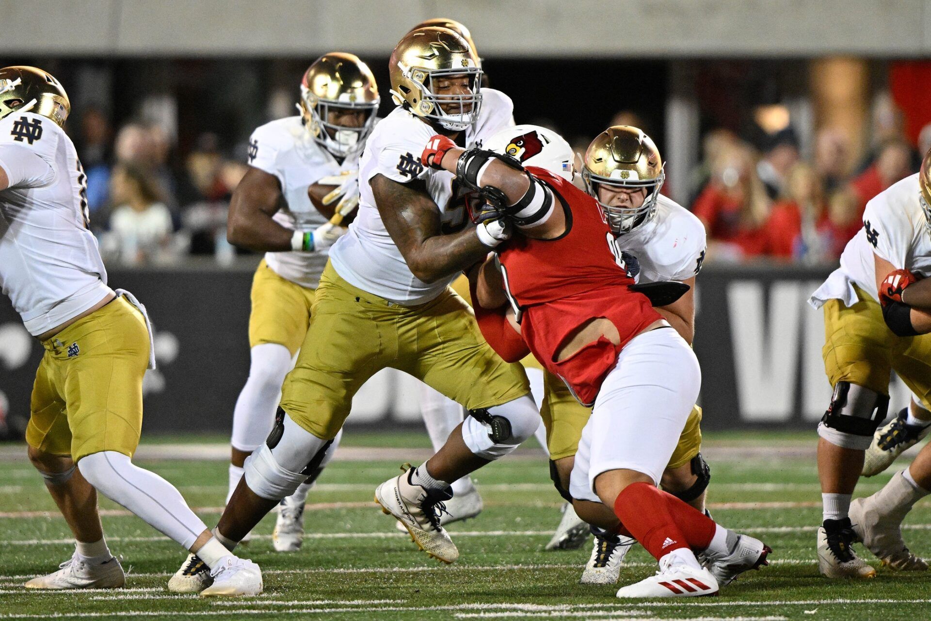 Notre Dame Fighting Irish offensive lineman Blake Fisher (54) blocks Louisville Cardinals defensive lineman Jermayne Lole (90) during the first half at L&N Federal Credit Union Stadium.