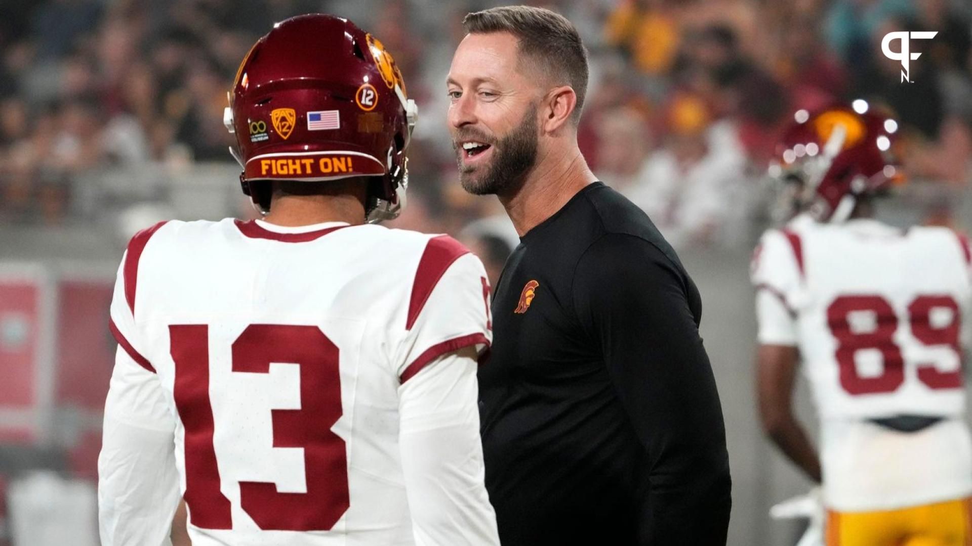 The former Arizona Cardinals head coach and now USC Trojans assistant coach Kliff Kingsbury talks to quarterback Caleb Williams (13) during the pregame warmup before playing the Arizona State Sun Devils at Mountain America Stadium in Tempe on Sept. 23, 2023.