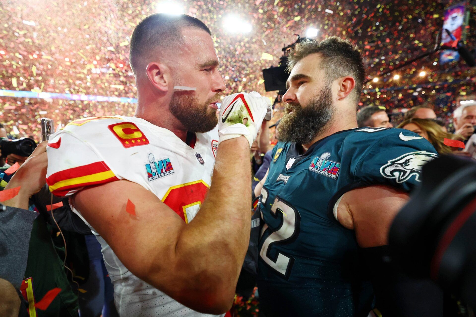 Kansas City Chiefs TE Travis Kelce (87) talks with his brother Philadelphia Eagles center Jason Kelce (62) after Super Bowl LVII.