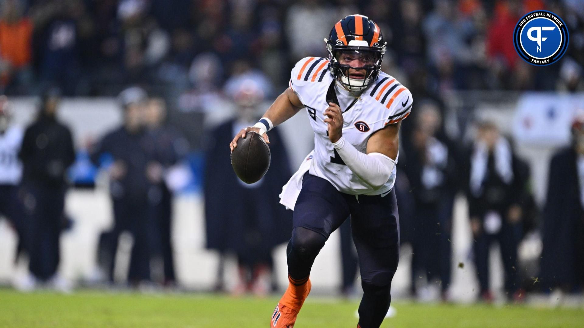 Chicago Bears quarterback Justin Fields (1) rolls out before tossing a 1-yard touchdown pass in the first half against the Arizona Cardinals at Soldier Field.